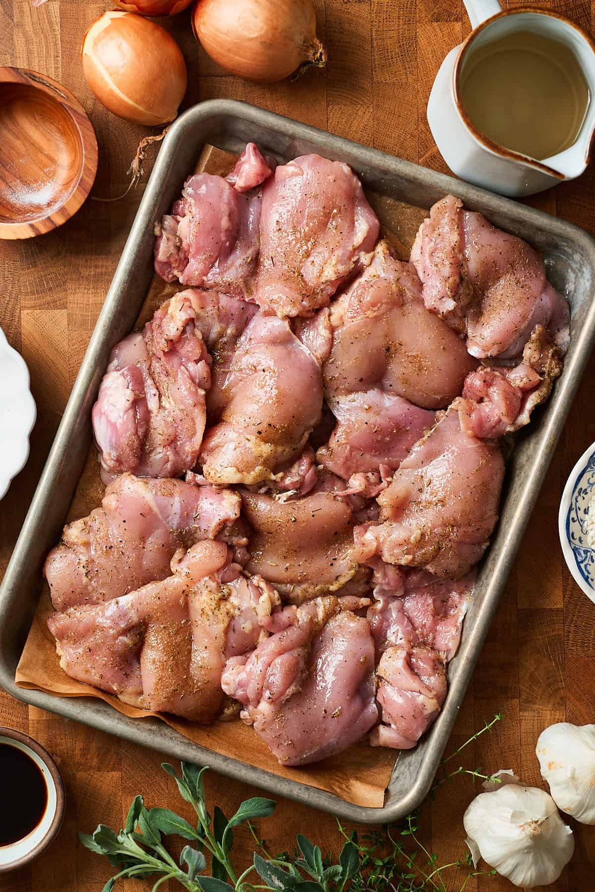 chicken thighs on a baking sheet coated with a few seasonings.