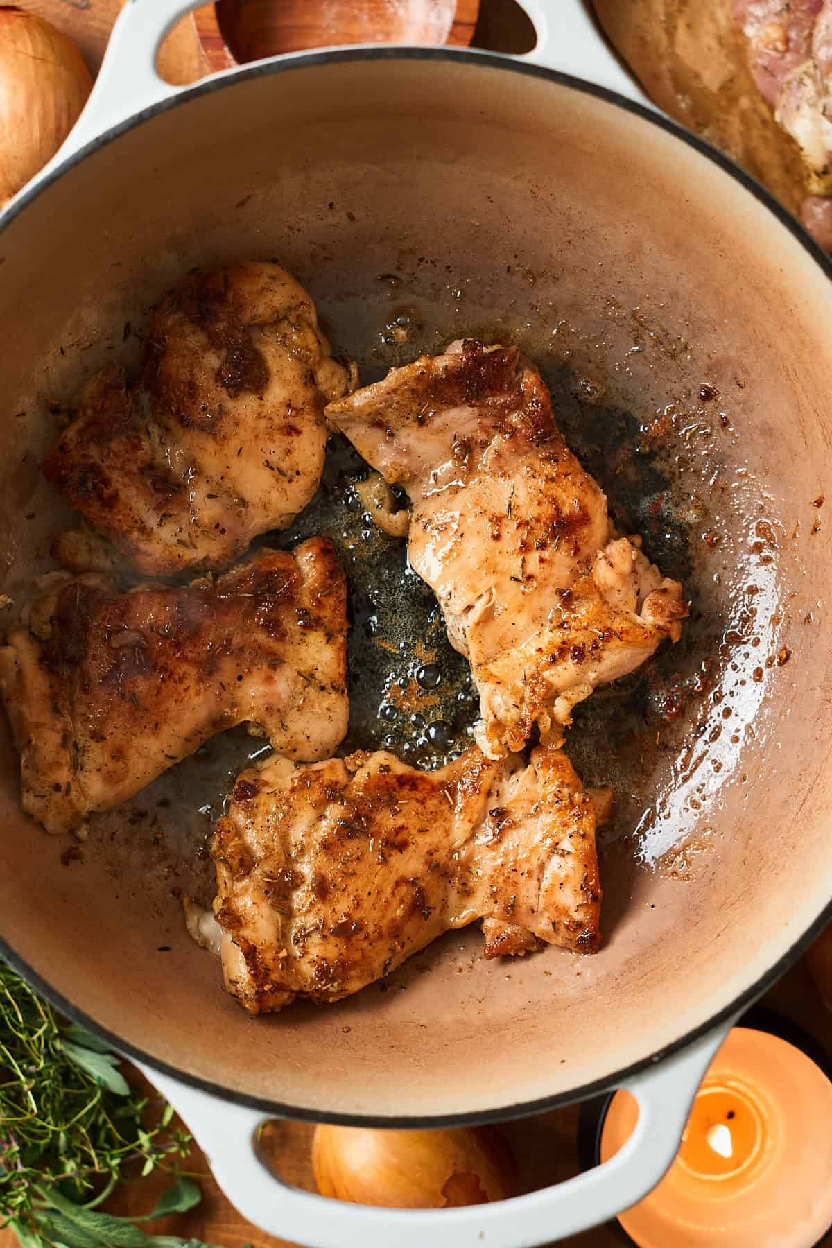 Cooked chicken thighs in a Dutch oven.