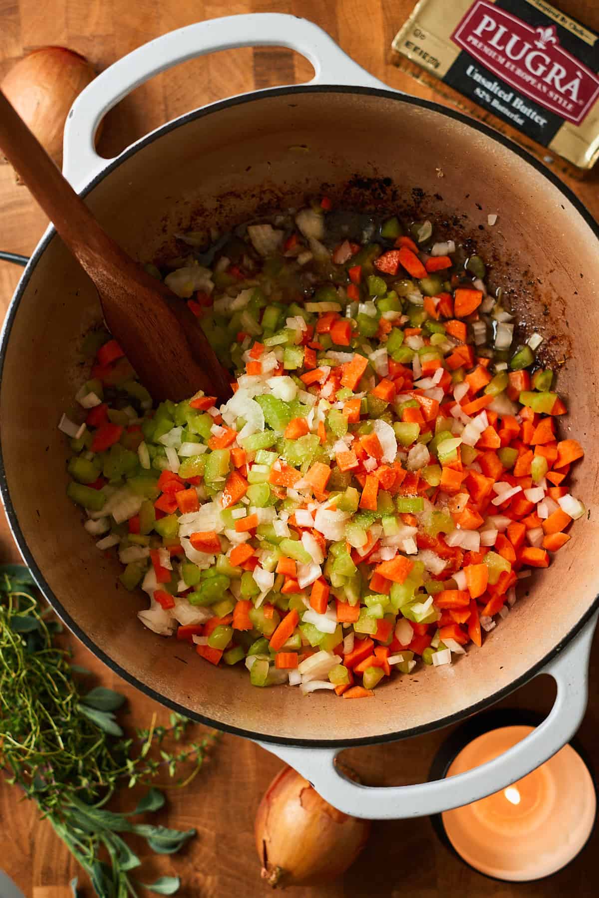 Vibrant celery, onion, and carrots in a Dutch oven.