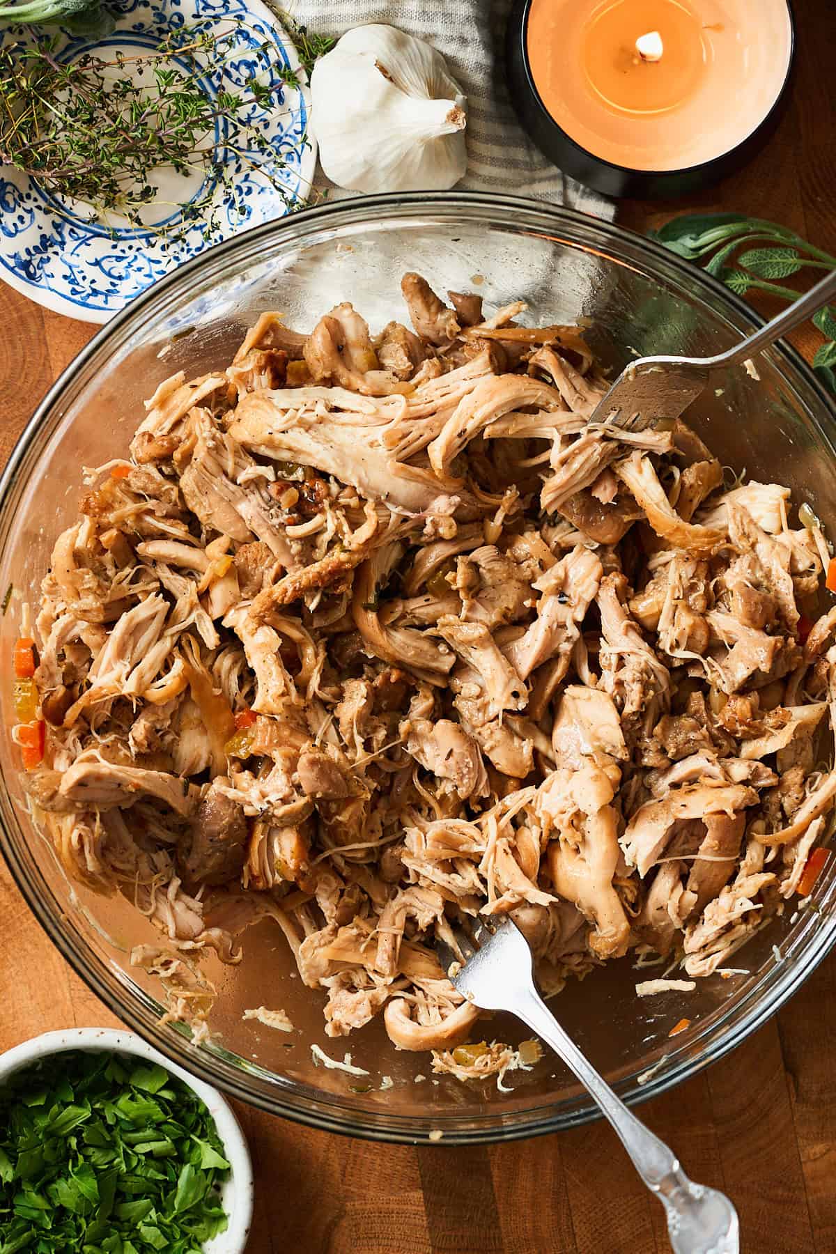 Shredded chicken thighs in a bowl with two forks.