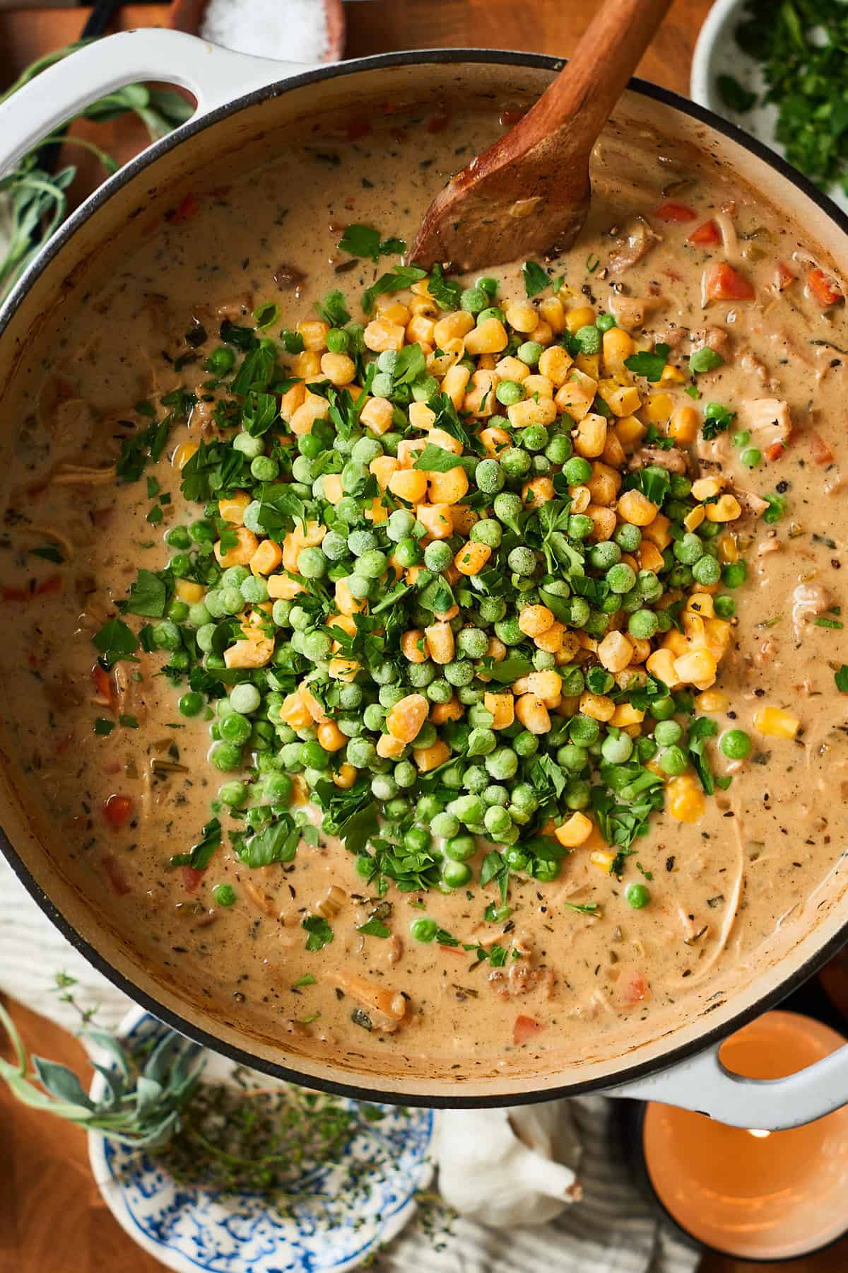 Creamy chicken pot pie soup with corn and peas added to the pot
