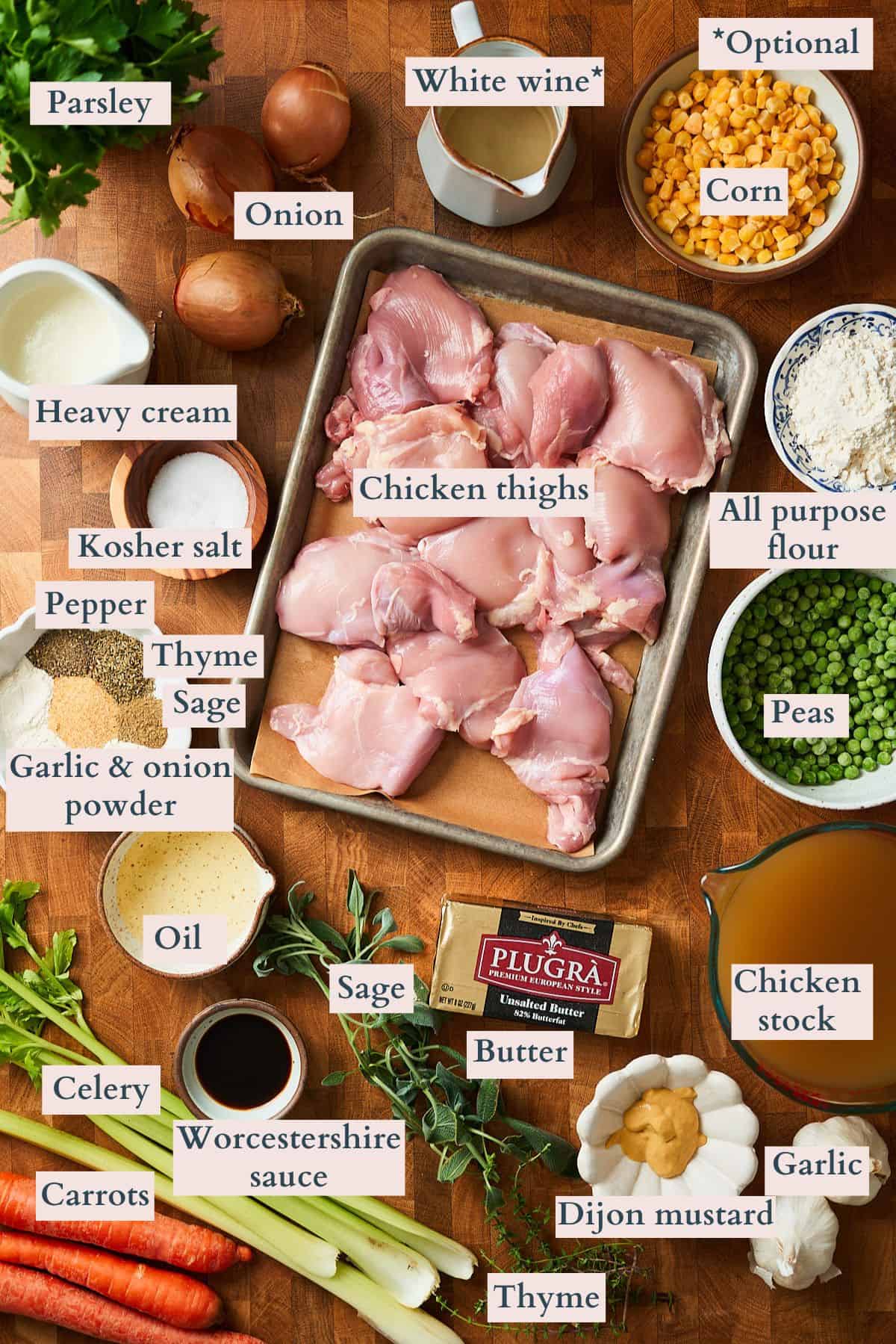 Ingredients to make chicken pot pie soup laid out on a table and labeled to show what each ingredient is.
