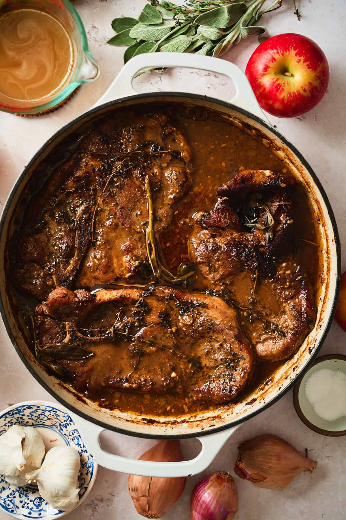Cooked pork steaks in a skillet in a rich gravy.