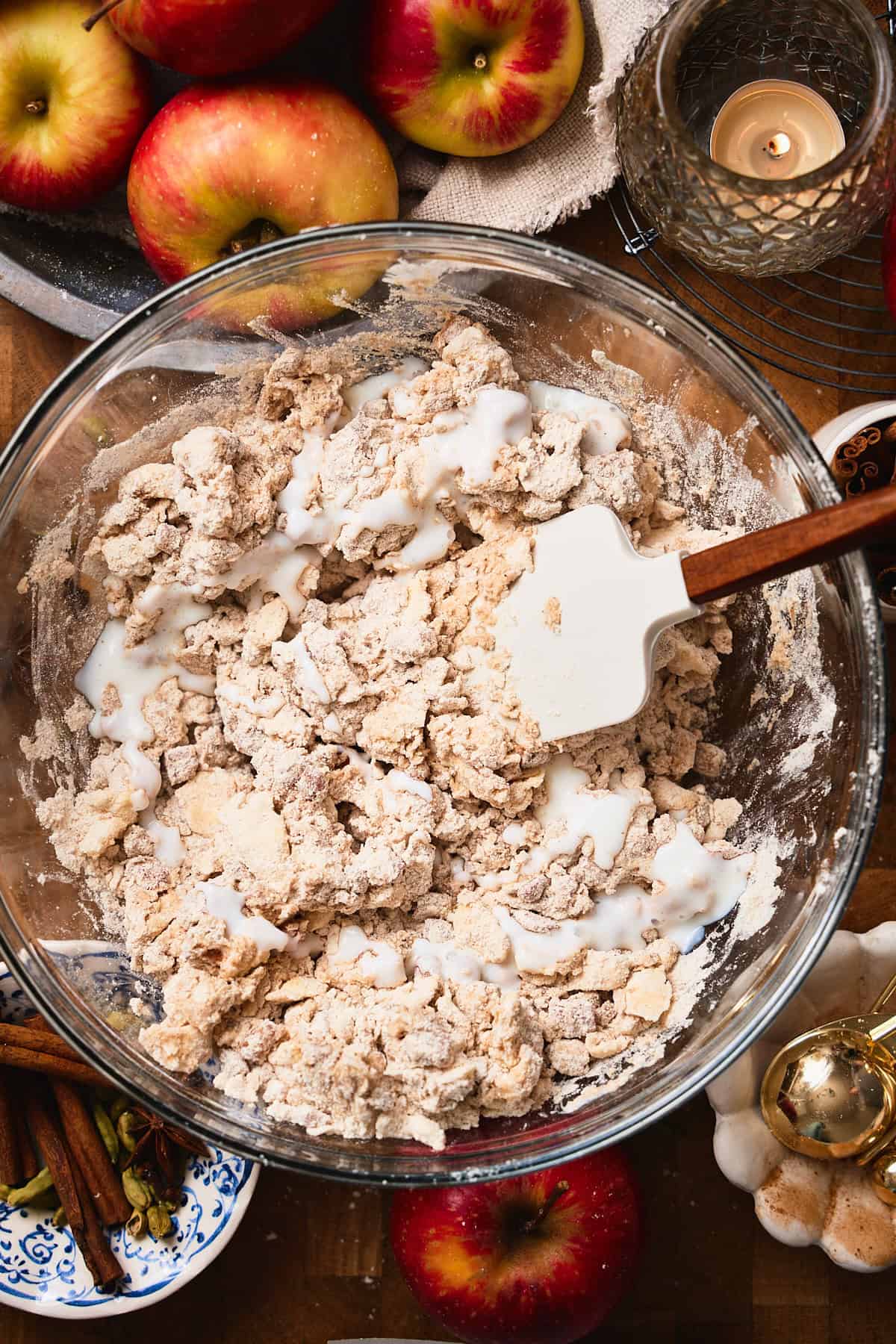Rubber spatula in a bowl folding buttermilk and dry ingredients together to make biscuits.