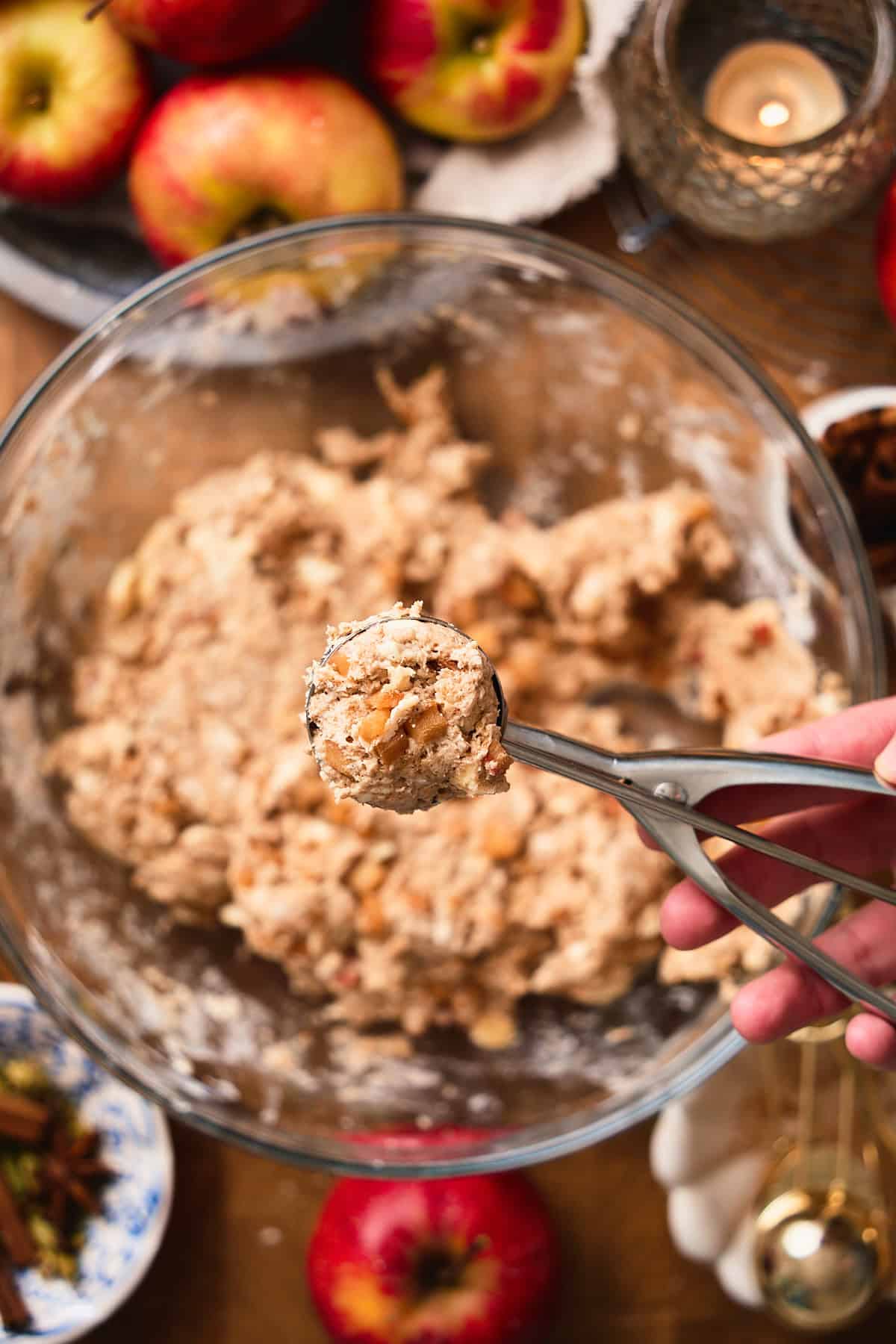 Hand holding a cookie scoop full of dough from a bowl.