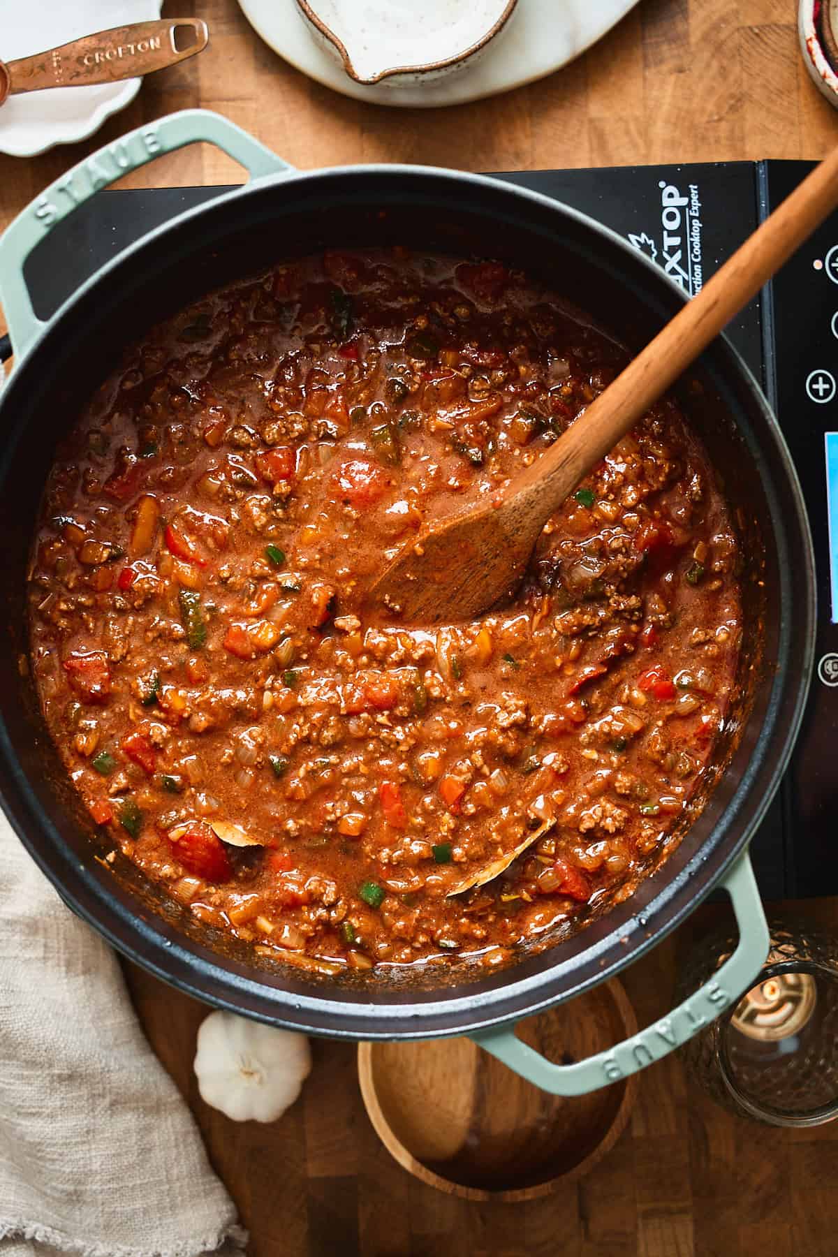 Dark beer chili simmering and thickening with ground beef and tomatoes.