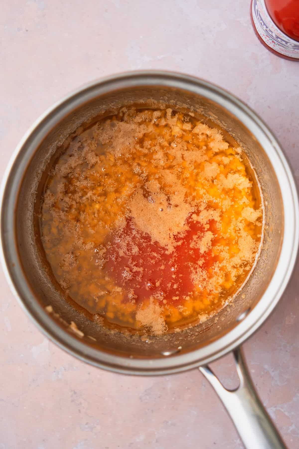 Melted butter in a pan with garlic, honey and hot sauce.