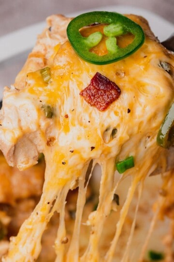 Spoonful of creamy, cheesy chicken with bacon and jalapenos being shown to the screen.