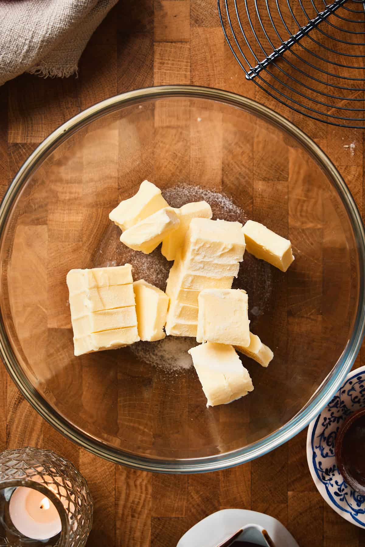 Softened butter chunks and salt in a glass mixing bowl, ready to whip.