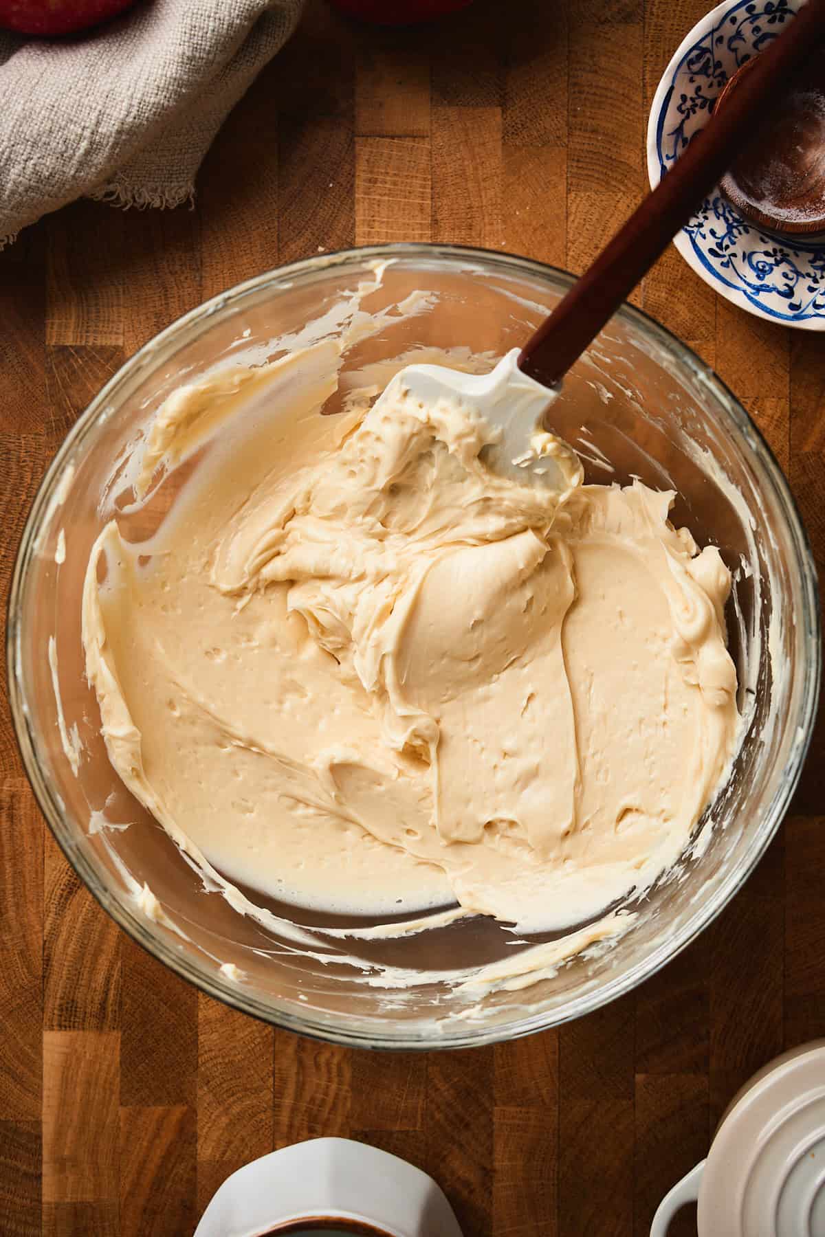Smooth and creamy whipped maple butter in a bowl with a rubber spatula incorporating everything.