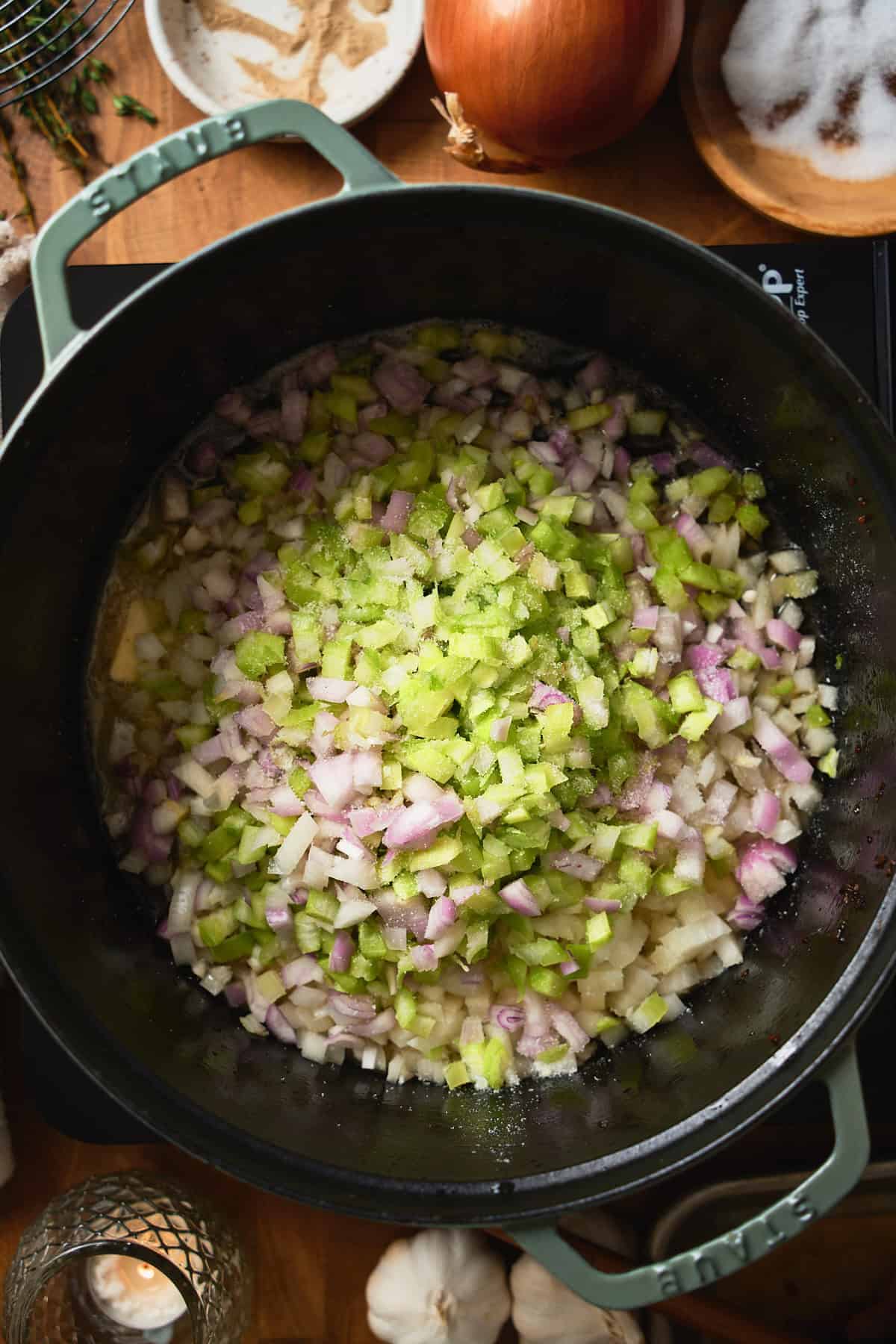 Celery, onions, and shallots added to a Dutch oven.