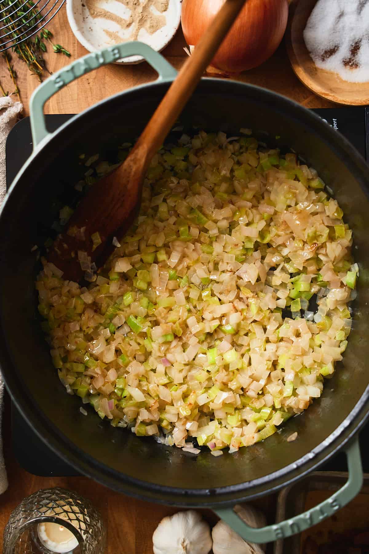 Softened onions, shallots, and celery cooking in bacon fat in a Dutch oven.