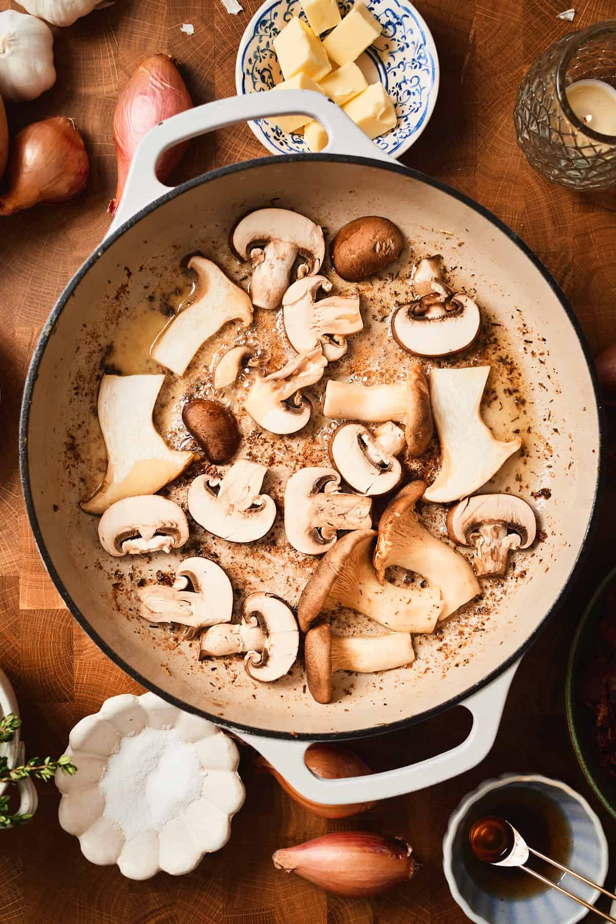 Raw mushroom pieces in a skillet getting golden brown and caramelized.