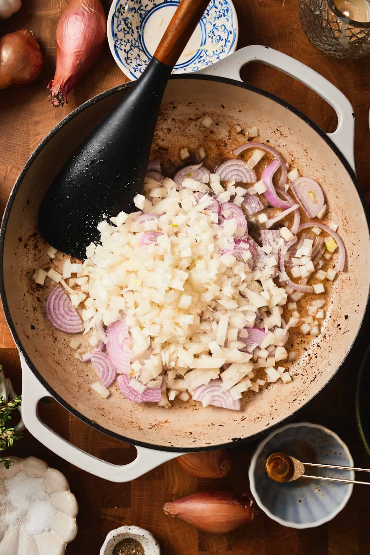 Shallots and onions in a skillet getting ready to cook.