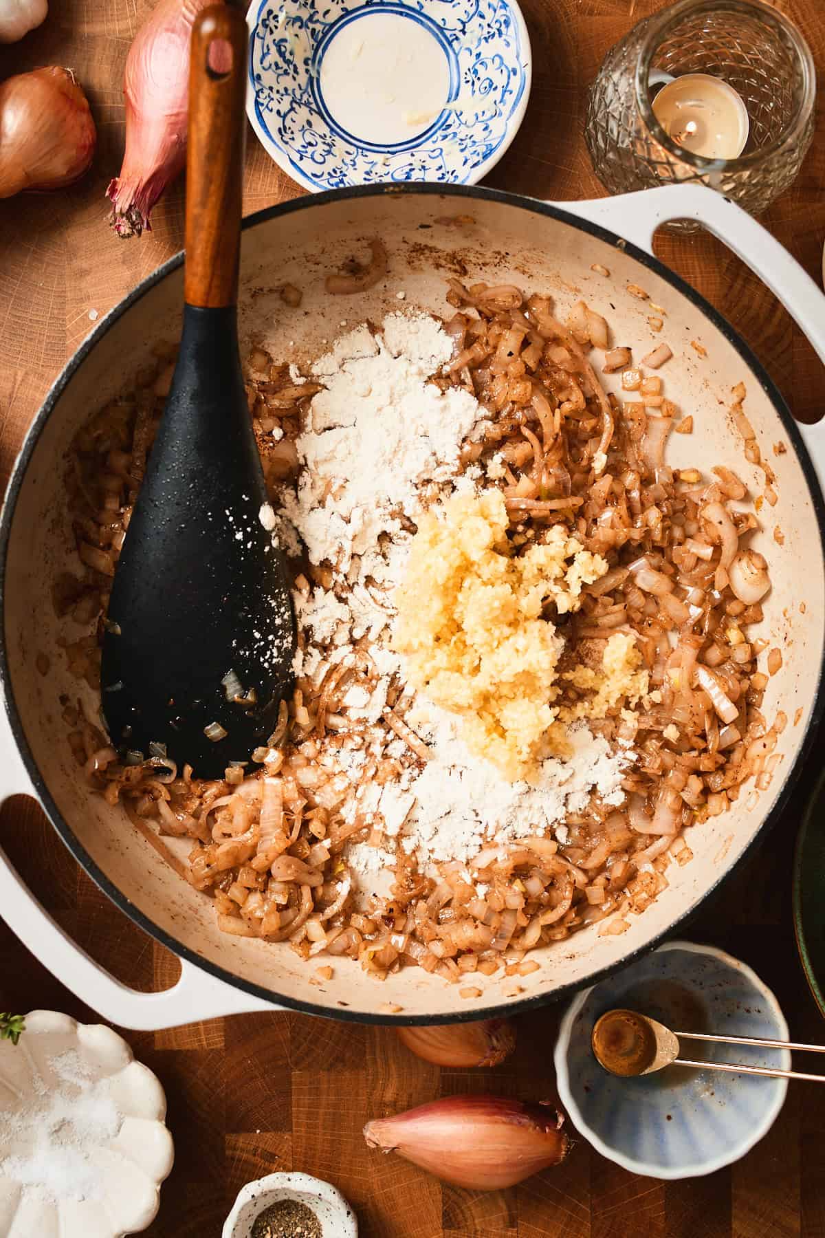 Cooked onions and shallots in a skillet with flour and garlic added.