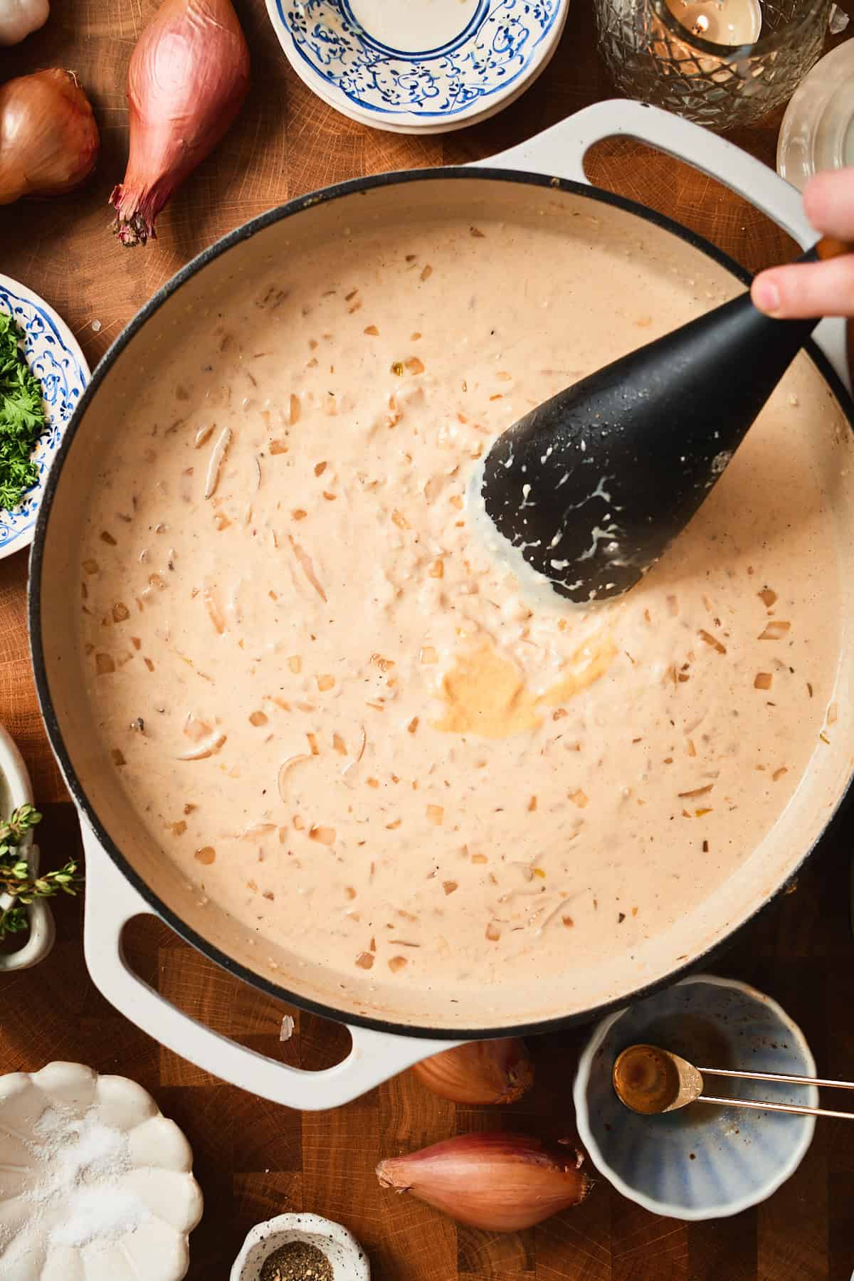 Cream and Dijon added a skillet with a hand stirring the creamy sauce.