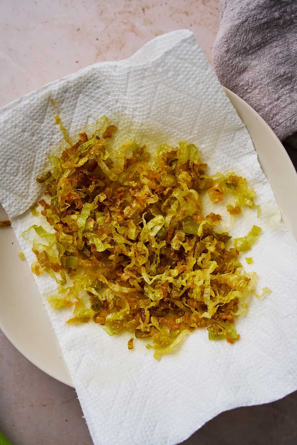 Crunchy leeks on a paper towel lined plate to catch extra grease.