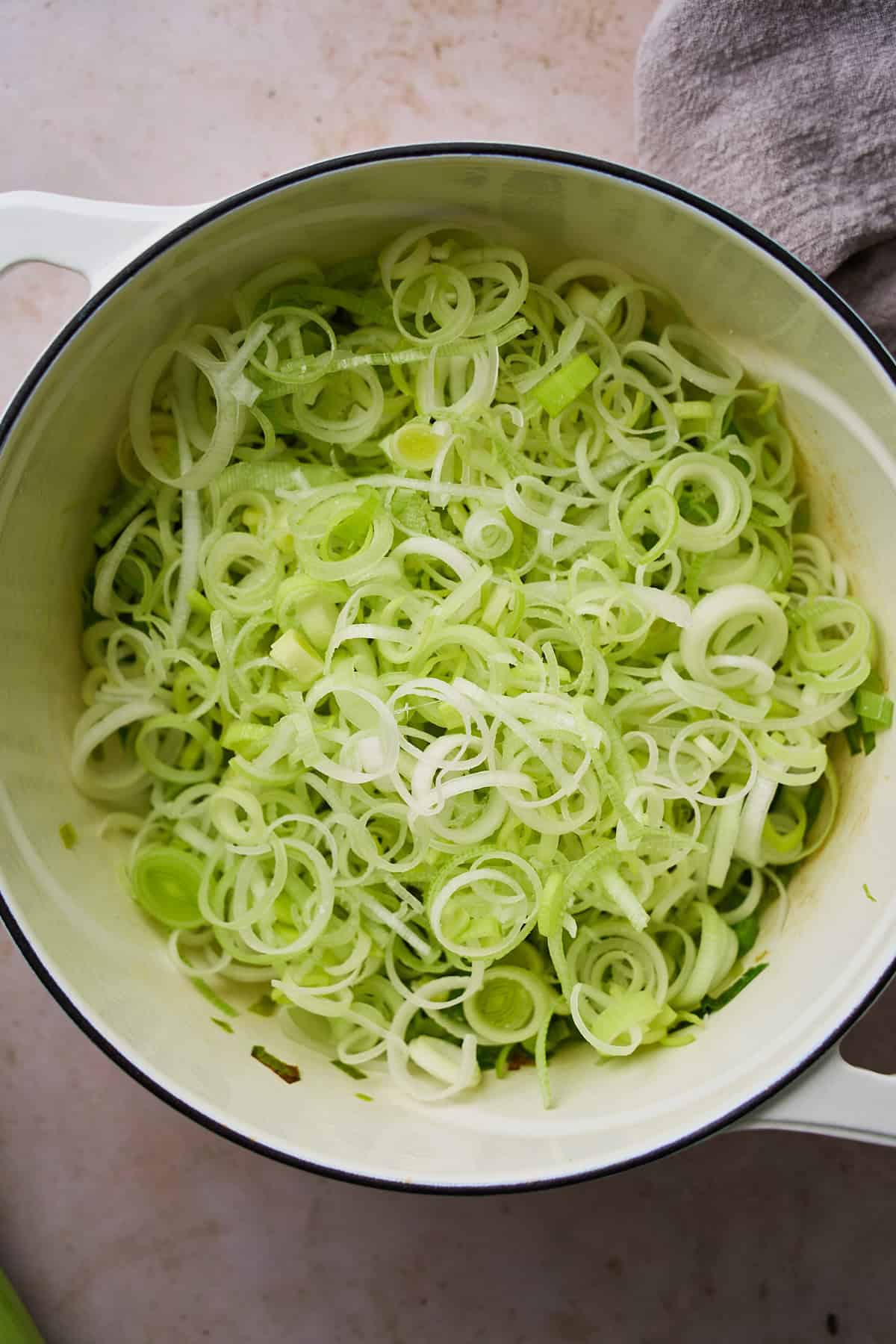 White and light green parts of the leeks added to a Dutch oven.