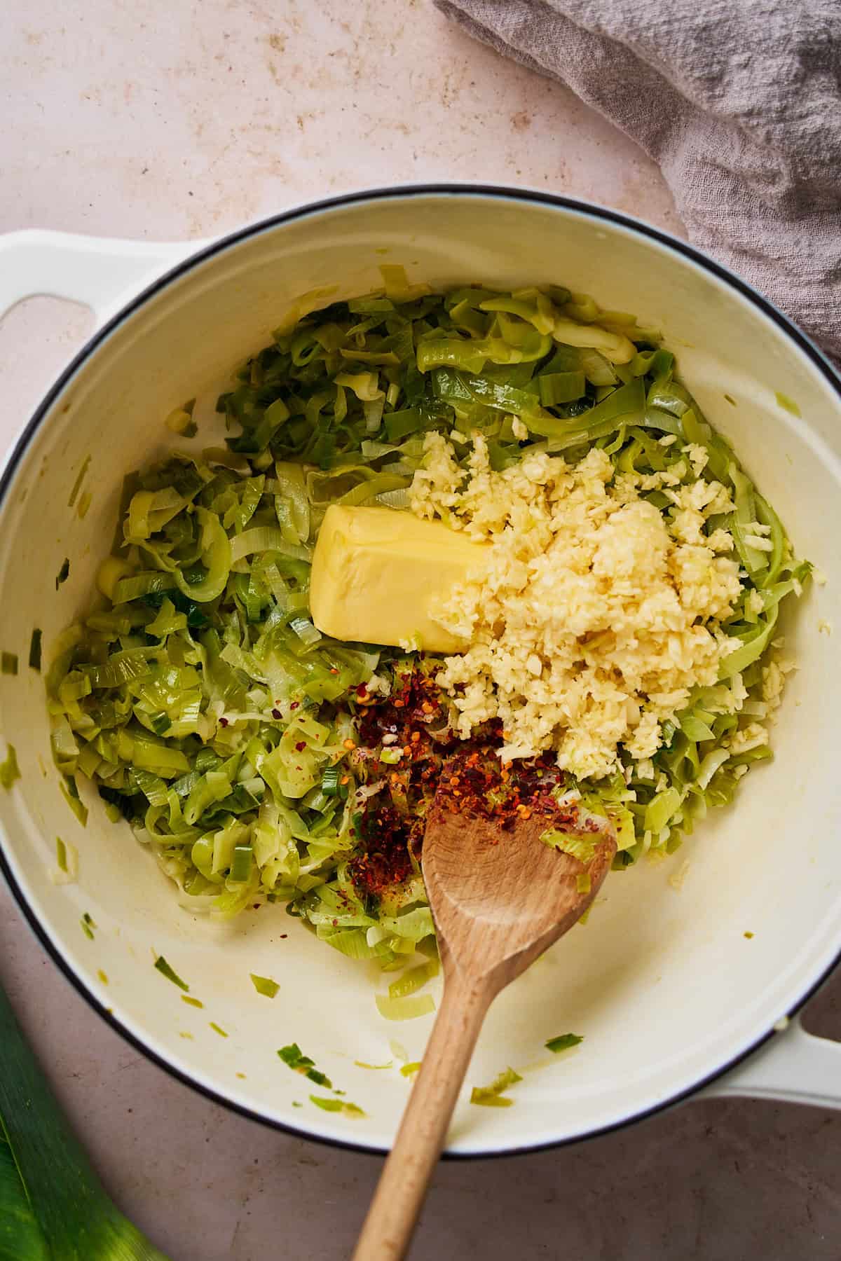 Garlic, red pepper flakes, and butter added to cooked leeks in a Dutch oven.