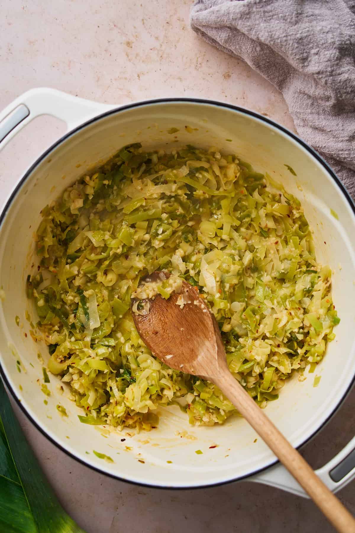 Cooked down leeks in a Dutch oven that have become caramelized.