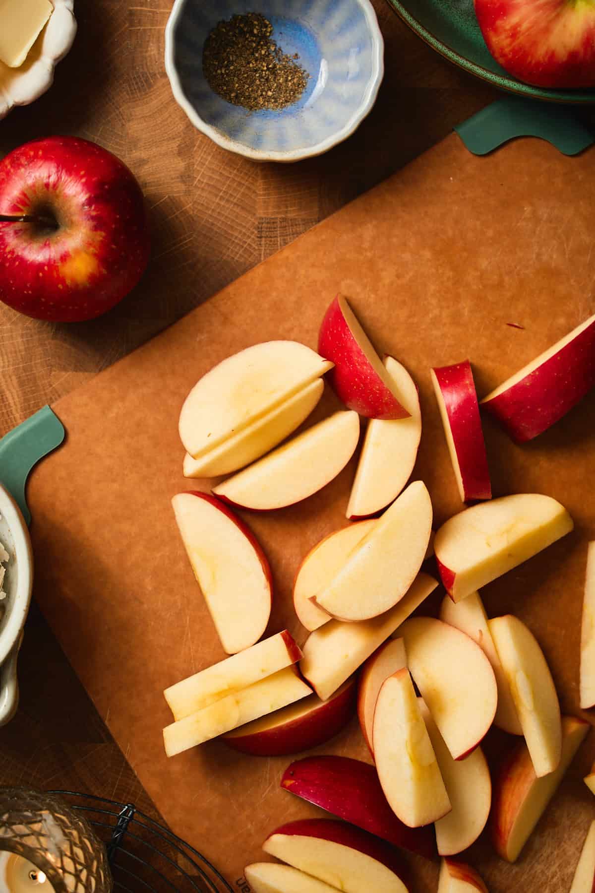 Thick-cut Michigan apple wedges on a wooden cutting board, ready for the sheet pan.
