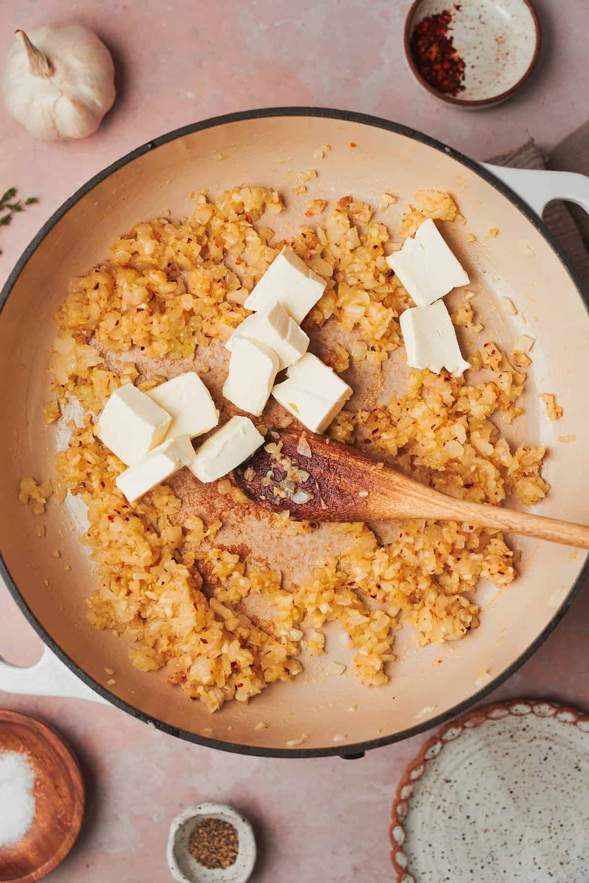 cream cheese added into a skillet with cooked onions.