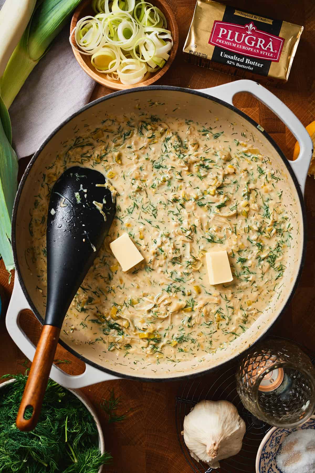 Two pats of cold butter resting in a creamy dill and leek sauce.