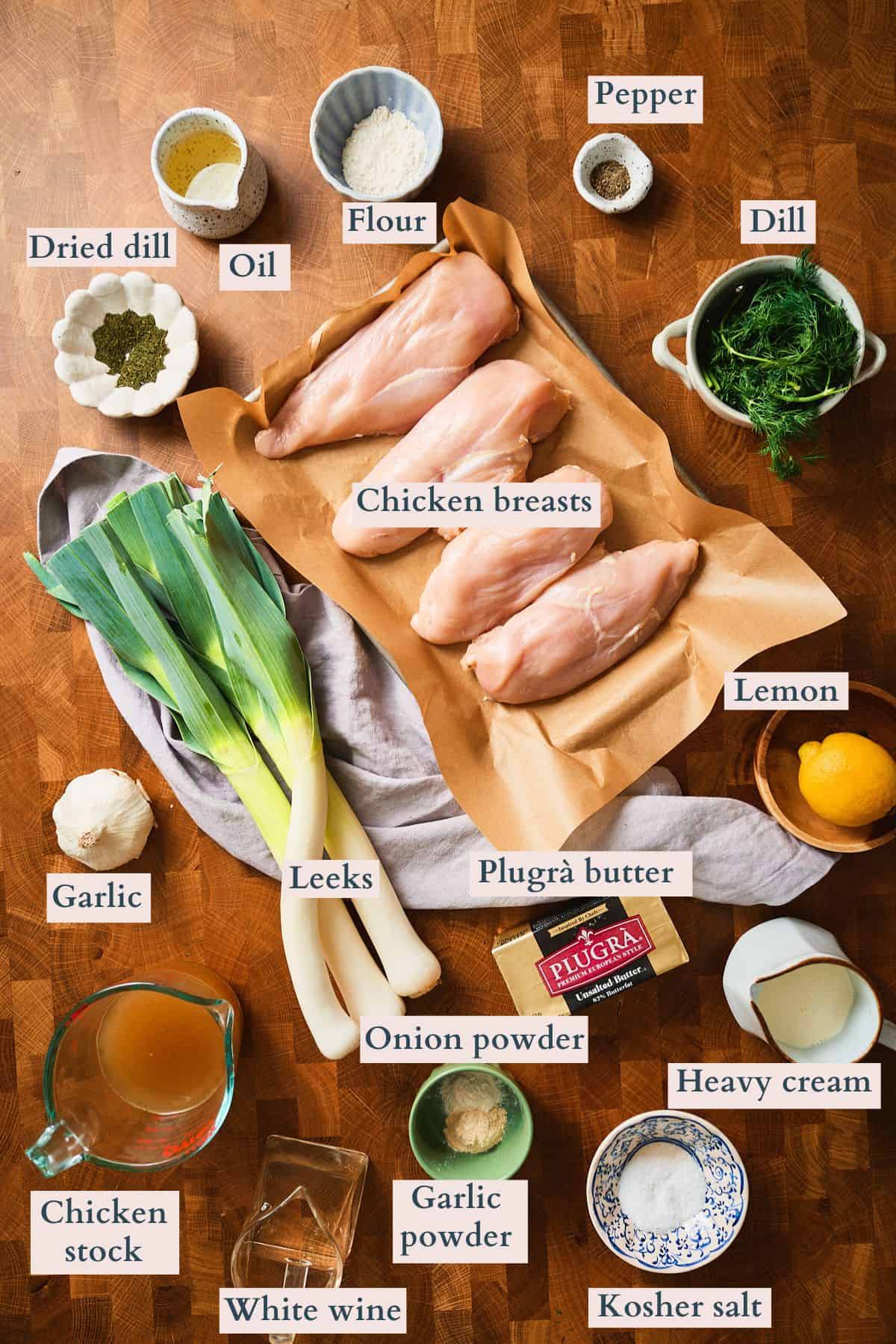 Ingredients to make creamy leek dill chicken laid out on a table and labeled.