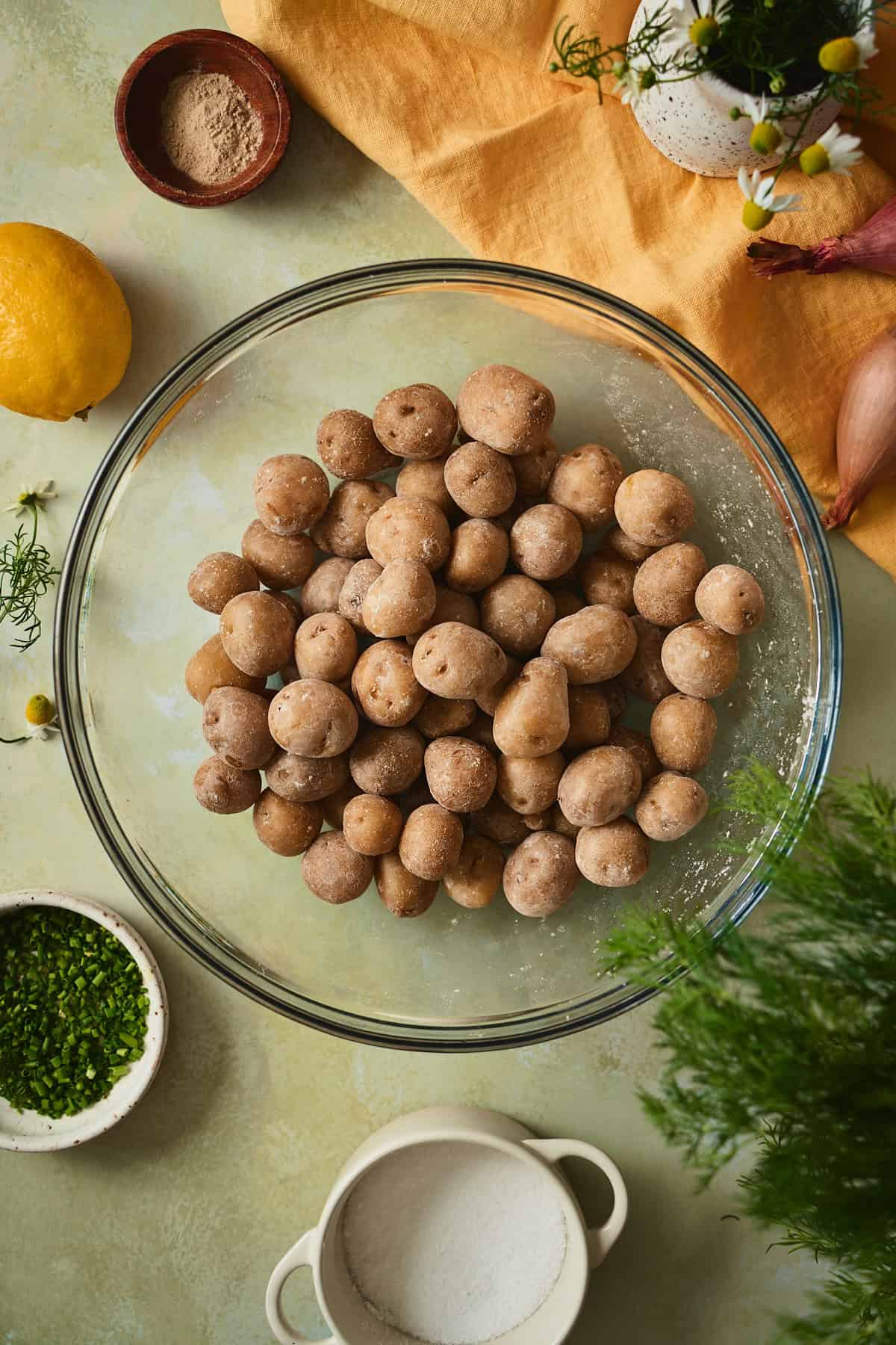 Boiled baby yellow potatoes coated in a thin layer of vinegar and salt, absorbing the seasoning while still warm.
