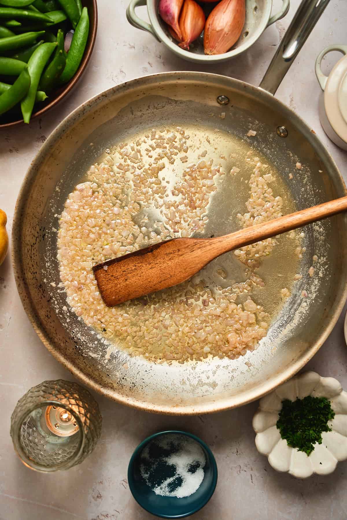Minced shallots cooking in melted butter in a skillet.