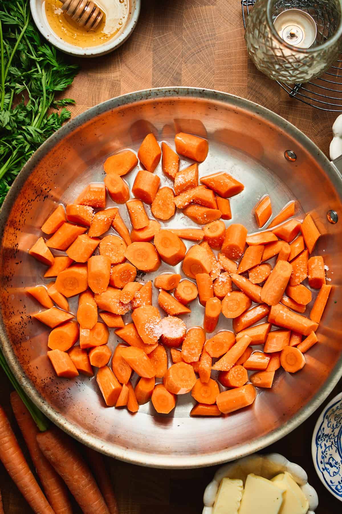 Sliced carrots in a skillet with water and kosher salt, ready to simmer.