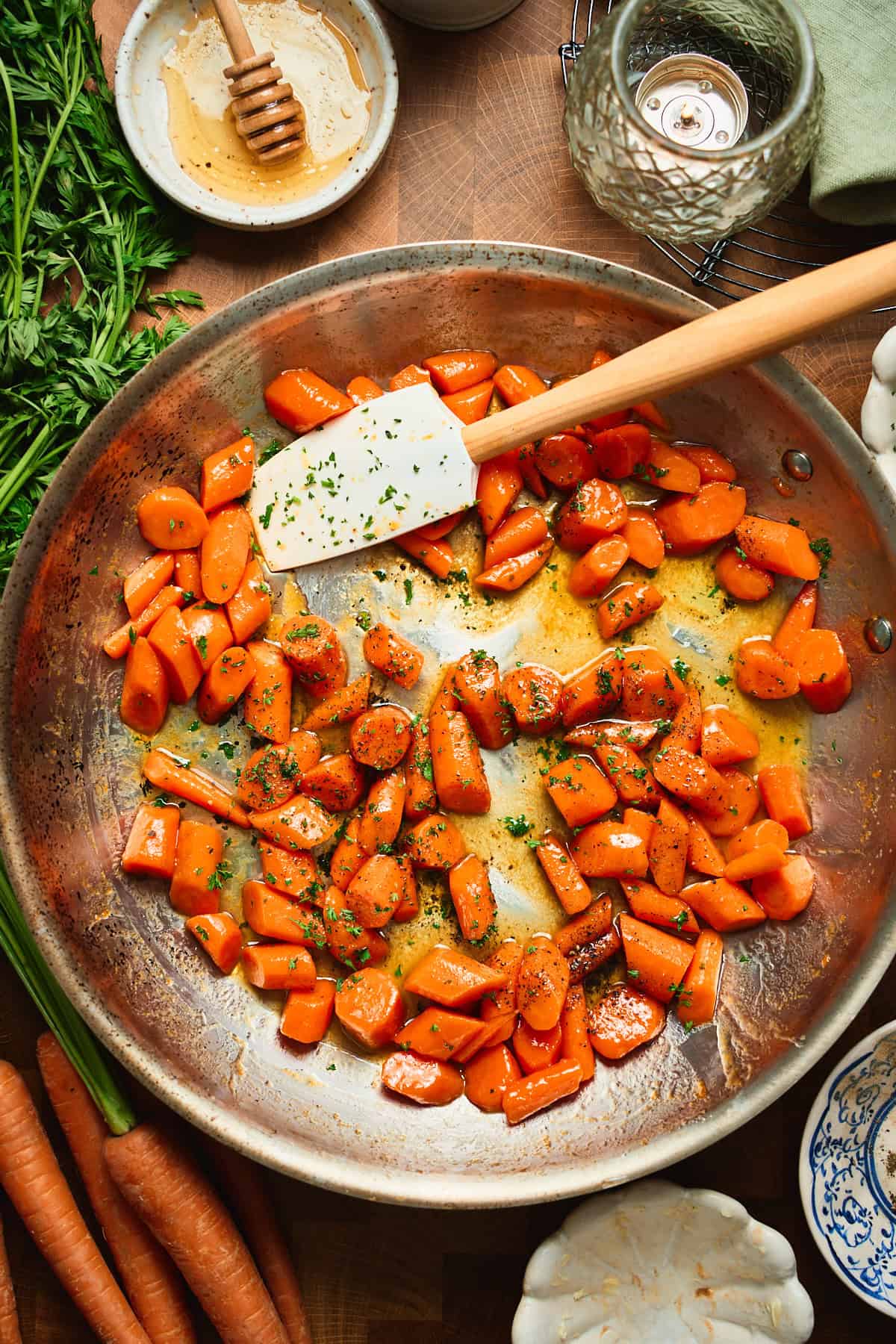 Honey butter glazed carrots tossed in a skillet with fresh parsley.