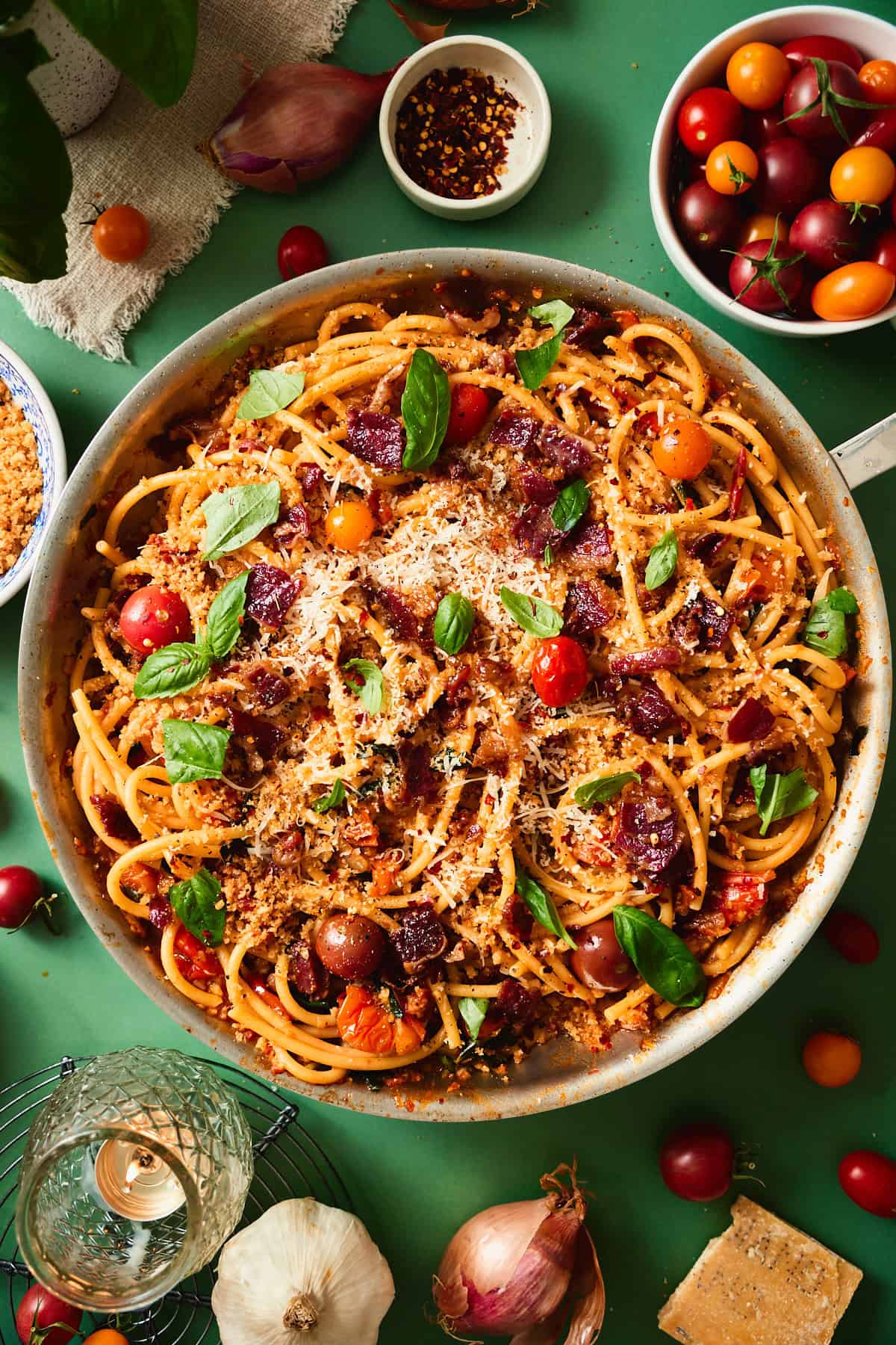 Finished bacon tomato pasta in a skillet topped with crispy beef bacon, toasted breadcrumbs, Parmesan, and fresh basil.