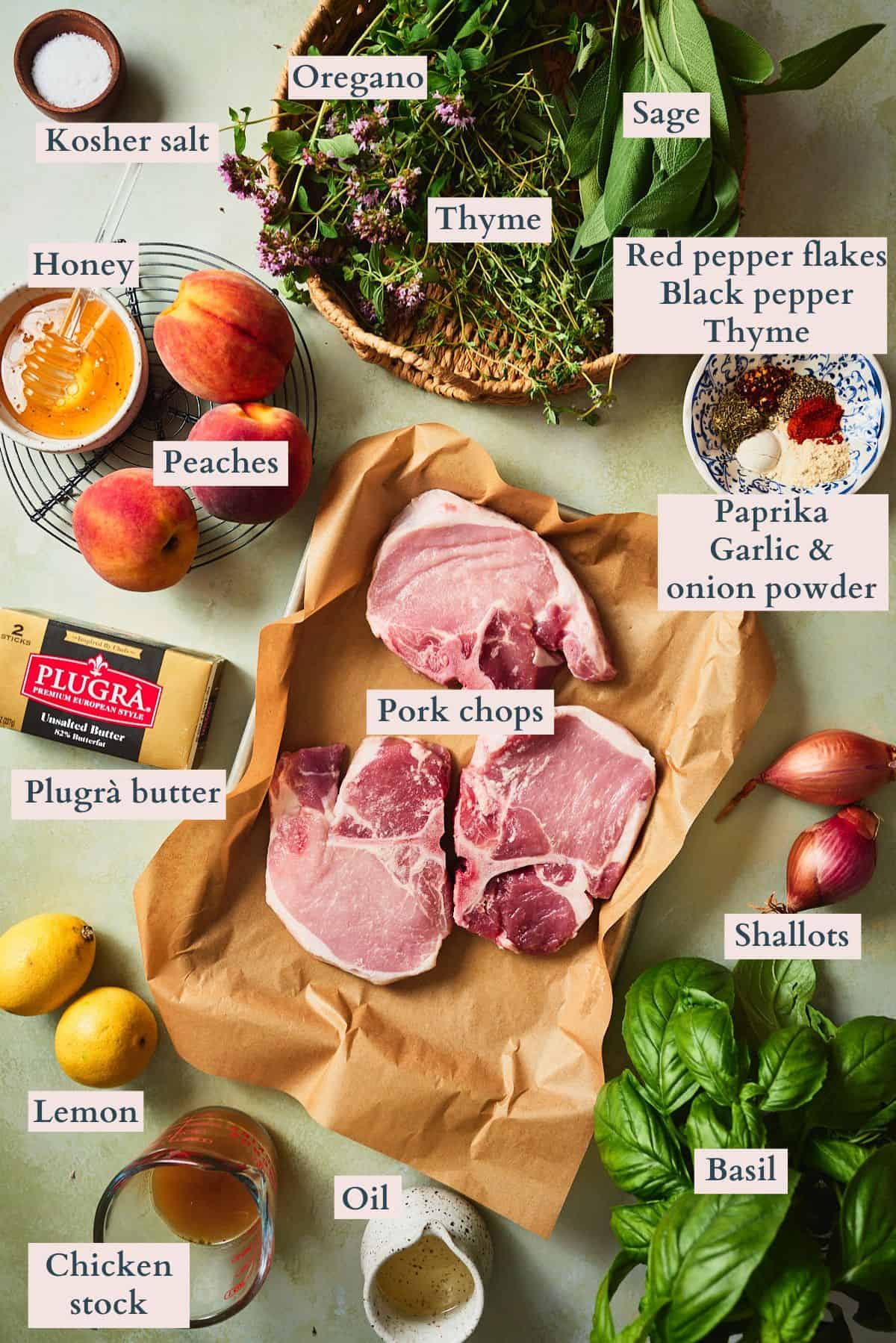 Ingredients for peach pork chops including bone-in chops, peaches, Plugrà butter, honey, lemons, shallots, and fresh herbs.