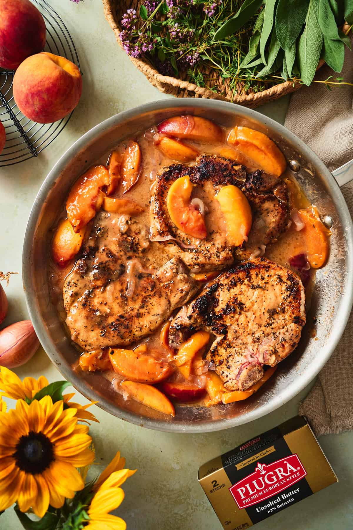 Seared pork chops returned to the skillet and spooned with peach brown butter sauce.