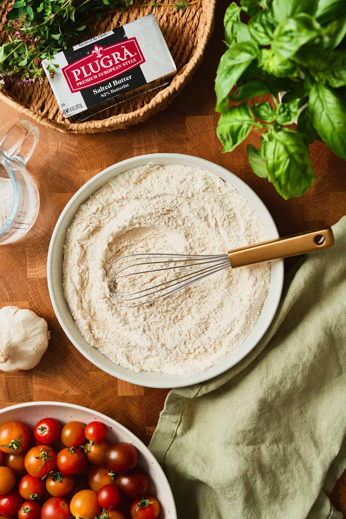 Flour, salt, and sugar whisked together in a ceramic bowl for tomato galette dough.