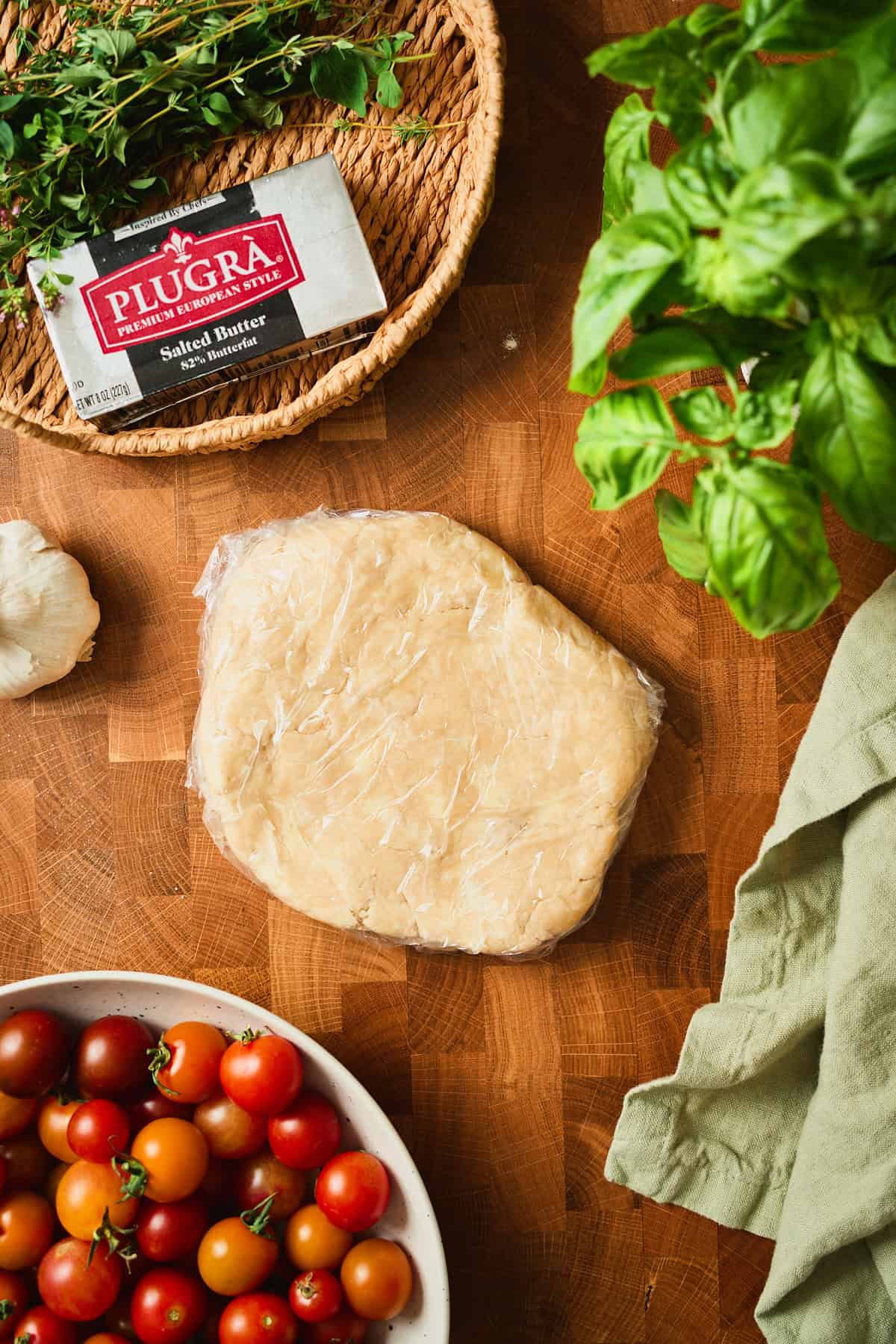 Galette dough flattened into a disk and wrapped in plastic to chill.