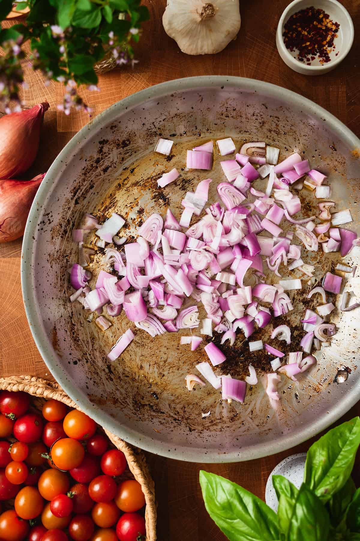 Diced shallot in a hot skillet with browned bits left from searing the chicken.