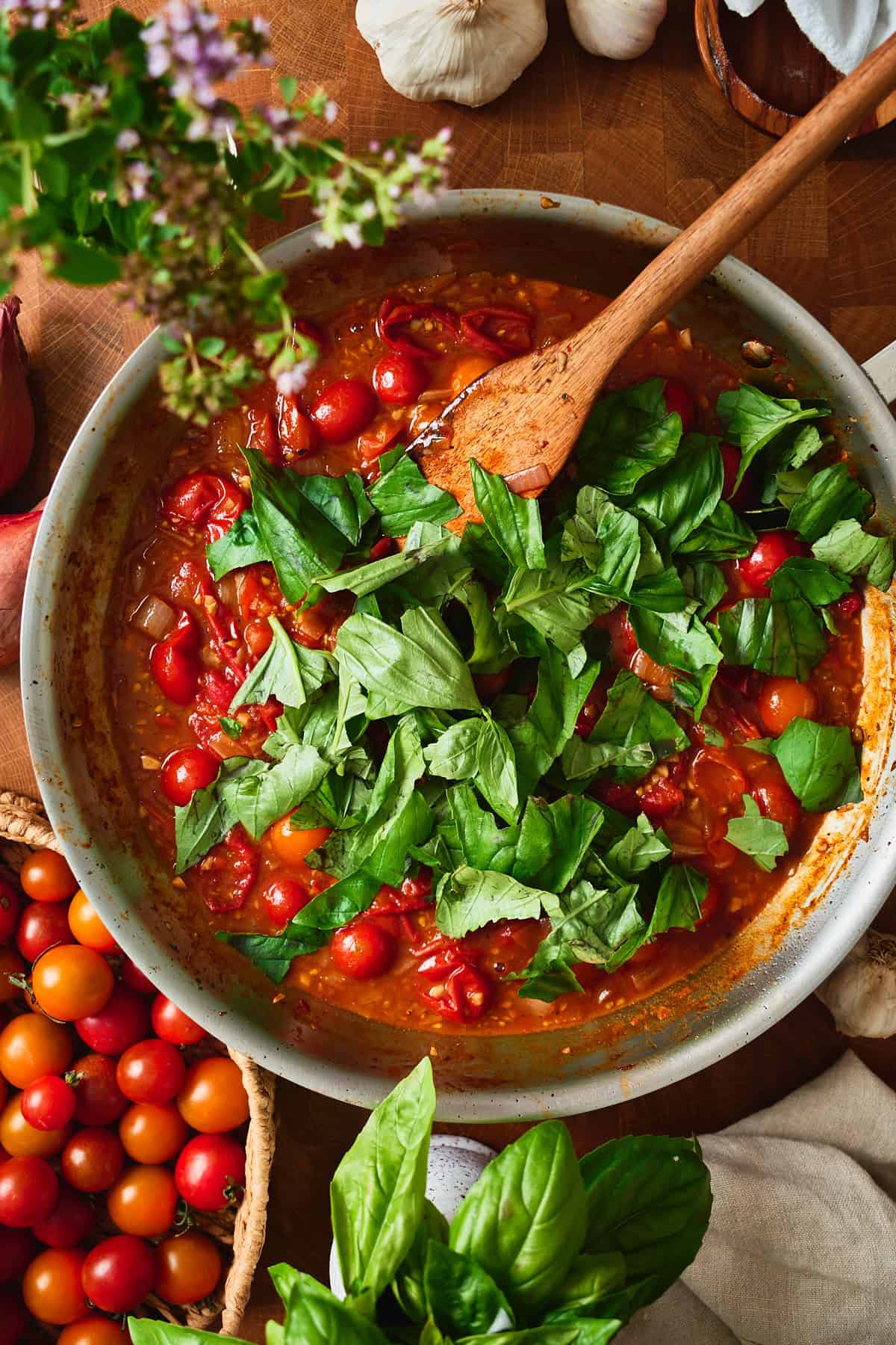 Torn fresh basil piled onto the finished cherry tomato pan sauce.