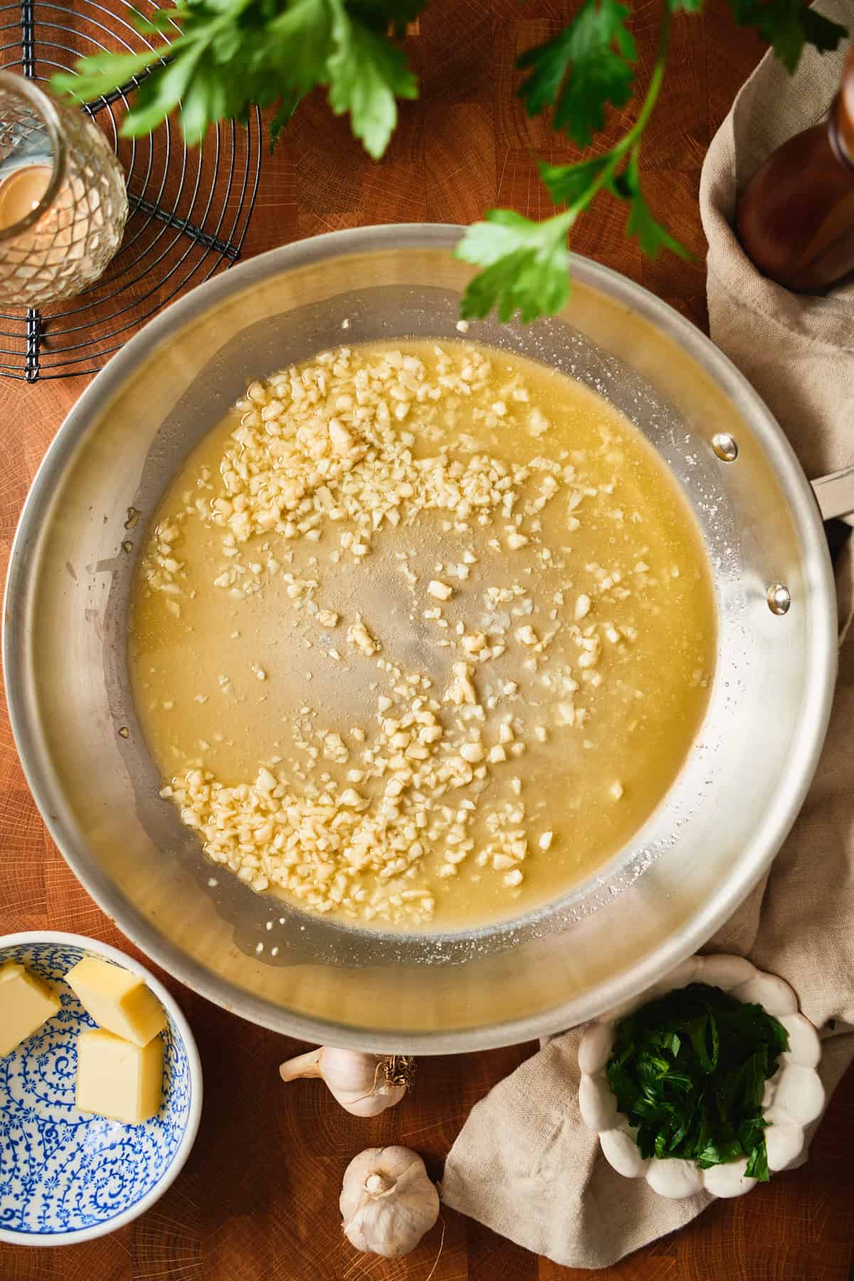 Minced garlic cooking gently in melted butter, overhead view of the skillet.