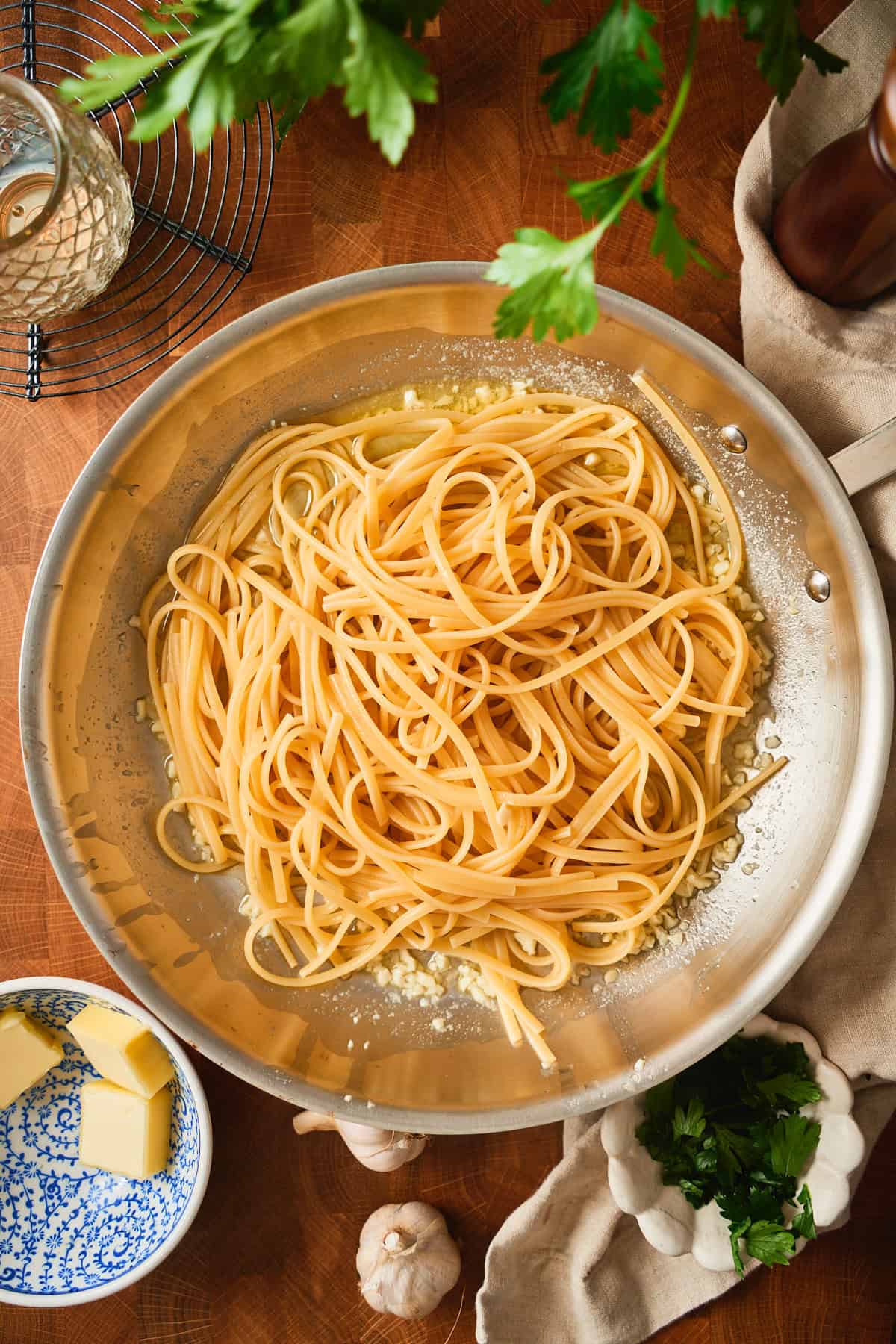 Drained linguine dropped into garlic butter in the skillet, before tossing.