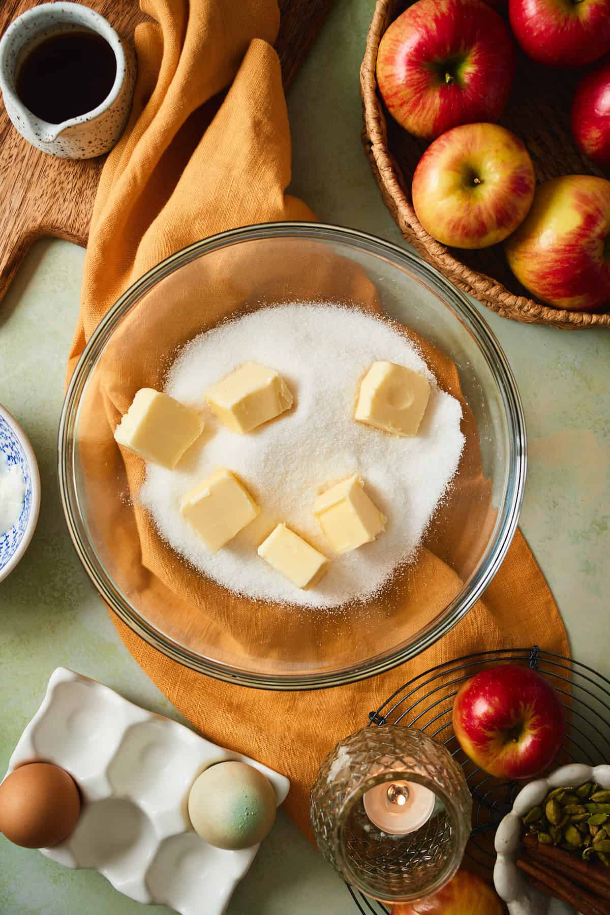 Cubed butter and granulated sugar in a glass mixing bowl.