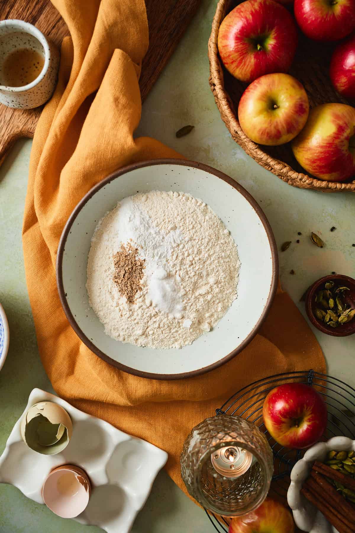 Flour, baking powder, ground cardamom, and salt in a ceramic bowl before whisking.