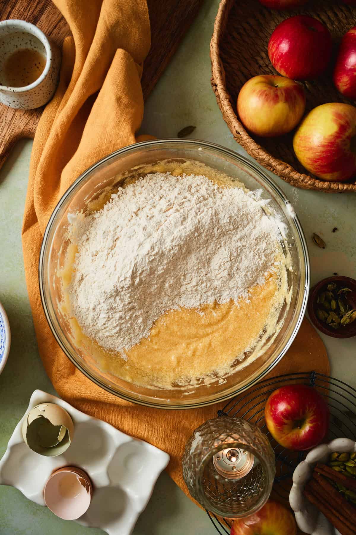 Dry ingredients added to the wet batter in a glass bowl.