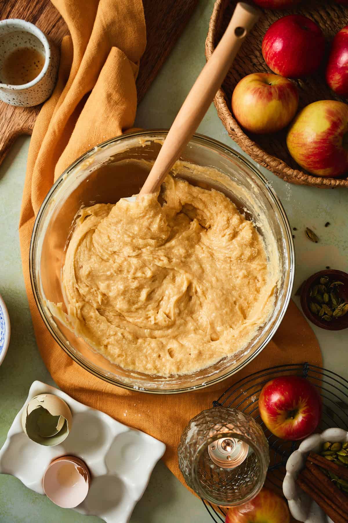 Thick Swedish apple cake batter holding spatula marks in a glass bowl.