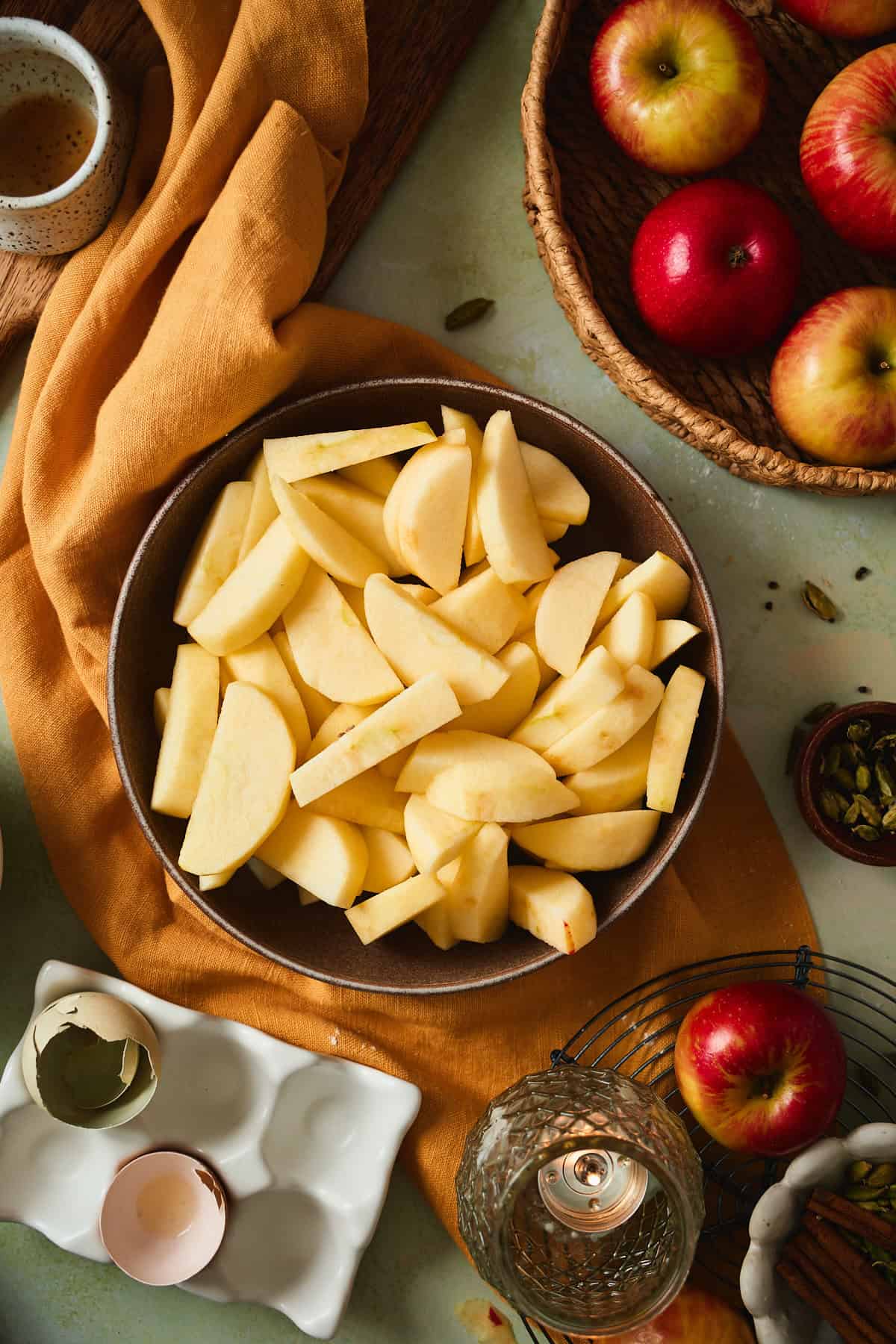 Peeled and cored apple wedges in a brown bowl.