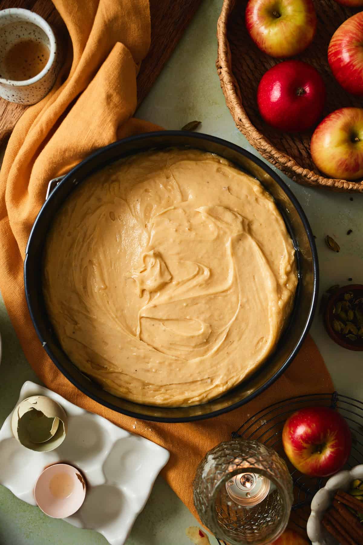 Cake batter spread and smoothed in a parchment-lined springform pan.