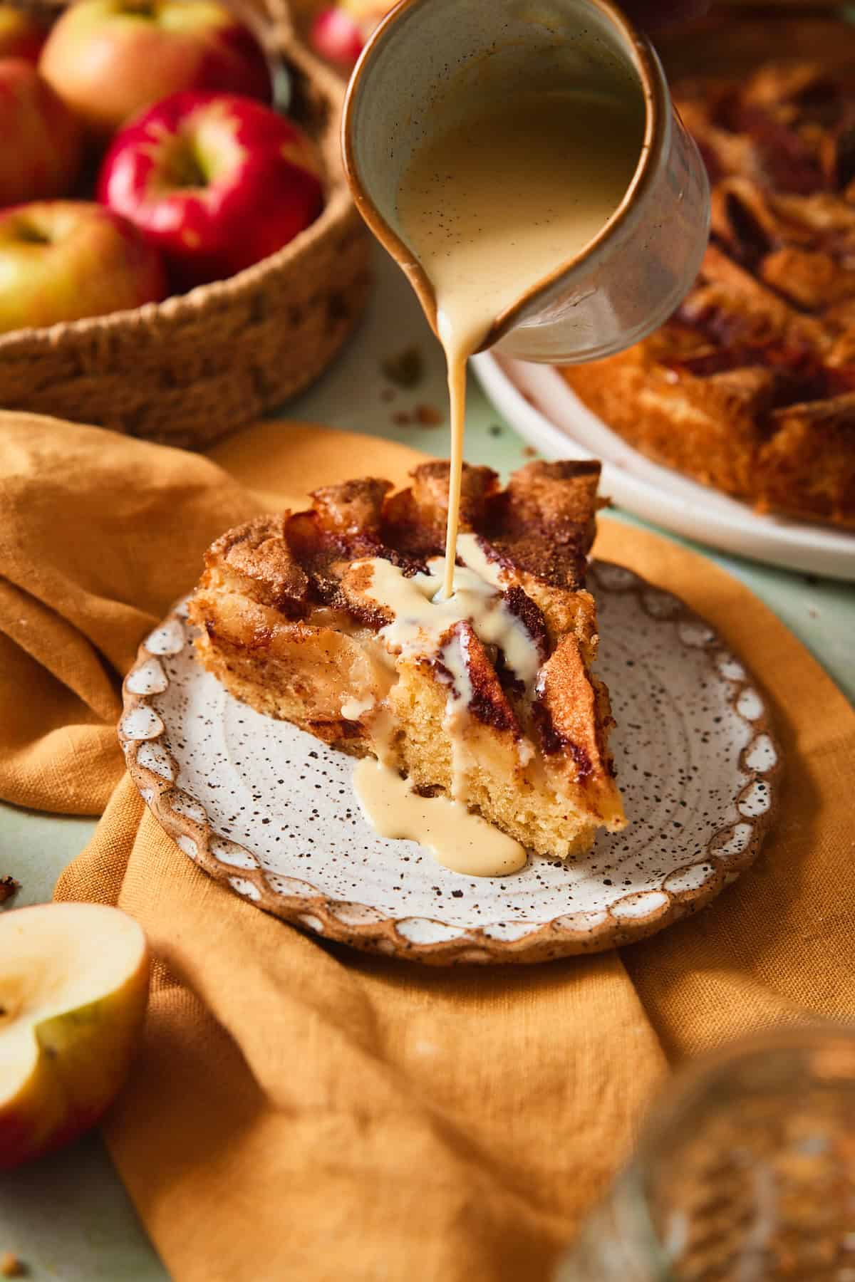 Vanilla sauce poured over a warm slice of Swedish apple cake.