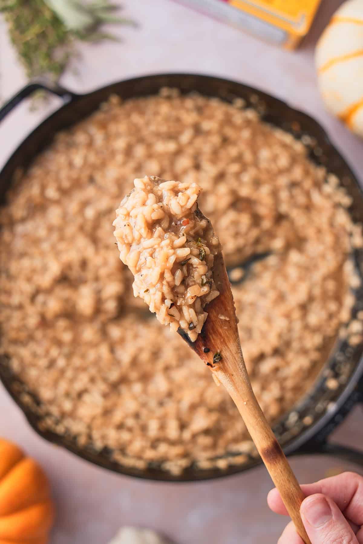Close-up of risotto rice in the skillet, grains plump and surrounded by starchy broth.