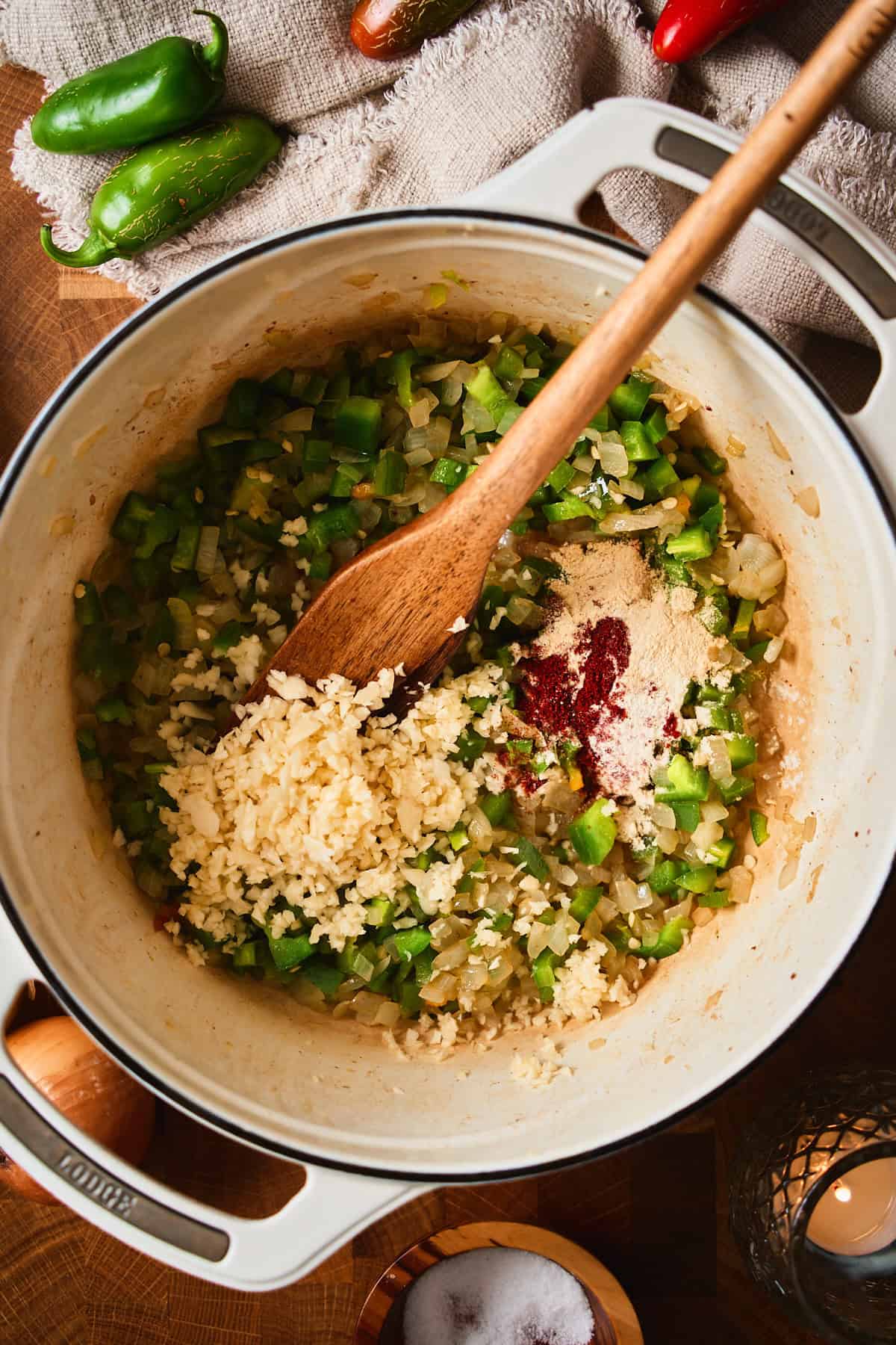 Minced garlic, onion powder, garlic powder, and smoked paprika added to onions and jalapeños in a Dutch oven.